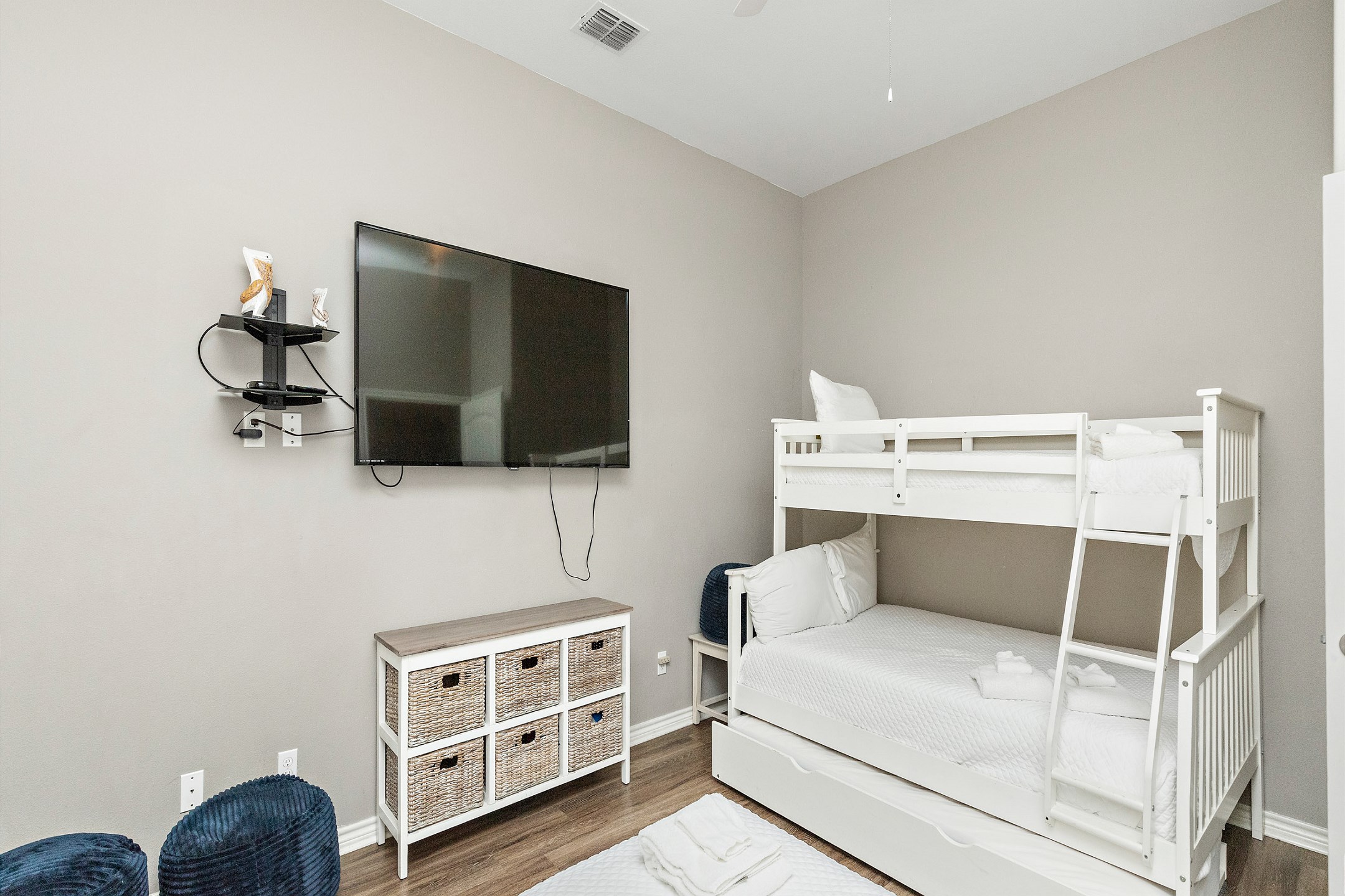 Second bedroom with queen size bed and twin bed over full size bunk bed with twin trundle, along with flat screen TV 
