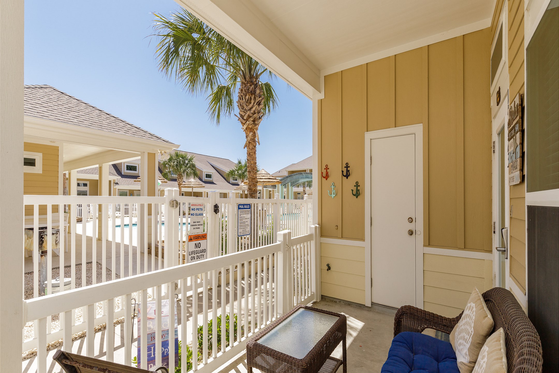 Charming corner patio with a pool view and cozy seating