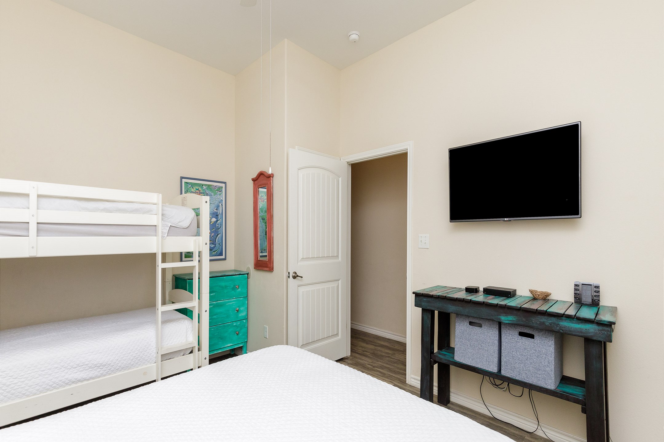 Second bedroom with queen size bed and twin size bunk beds, along with Apple TV