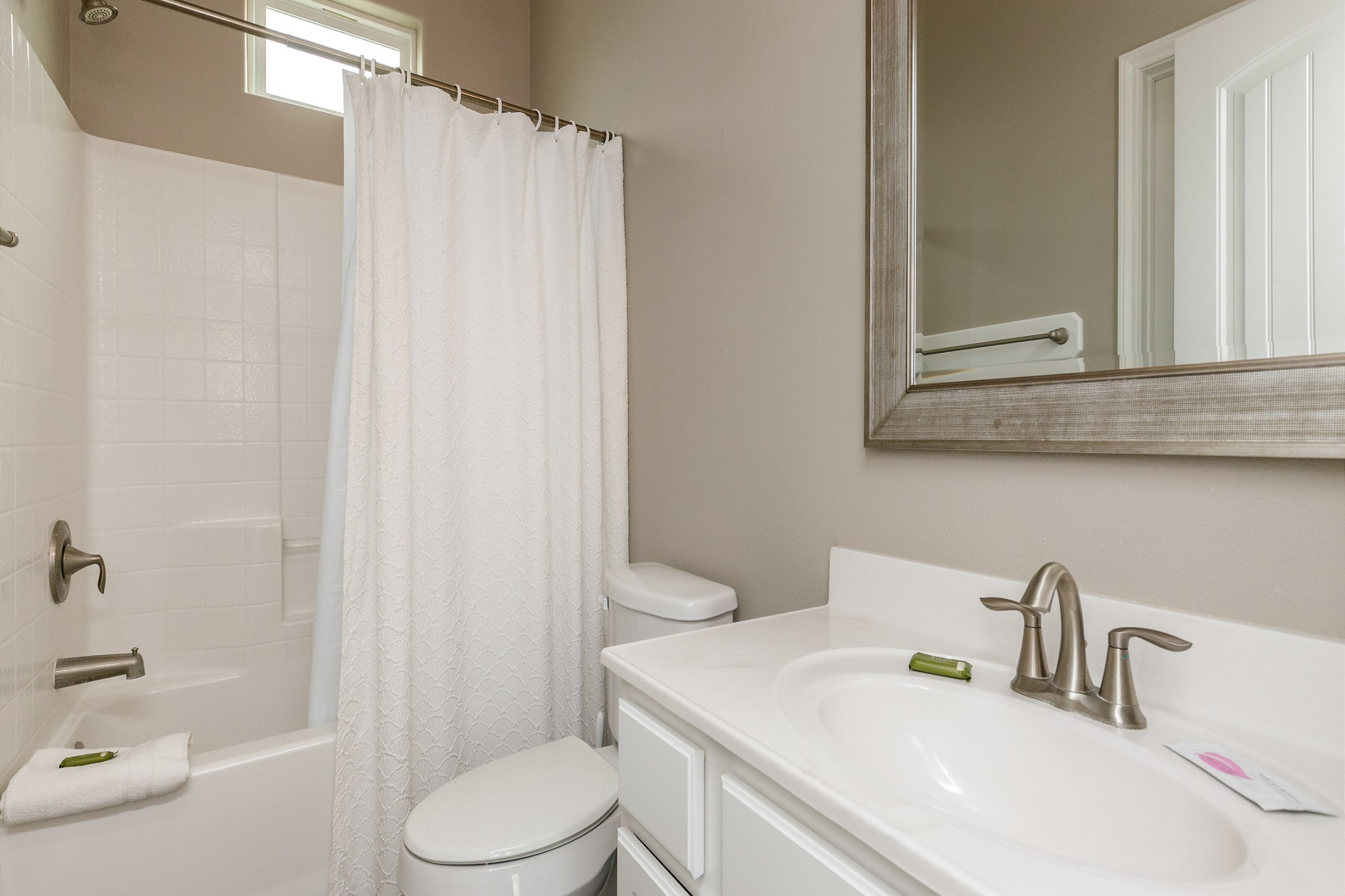 Private bathroom off the second bedroom with tub and shower combo