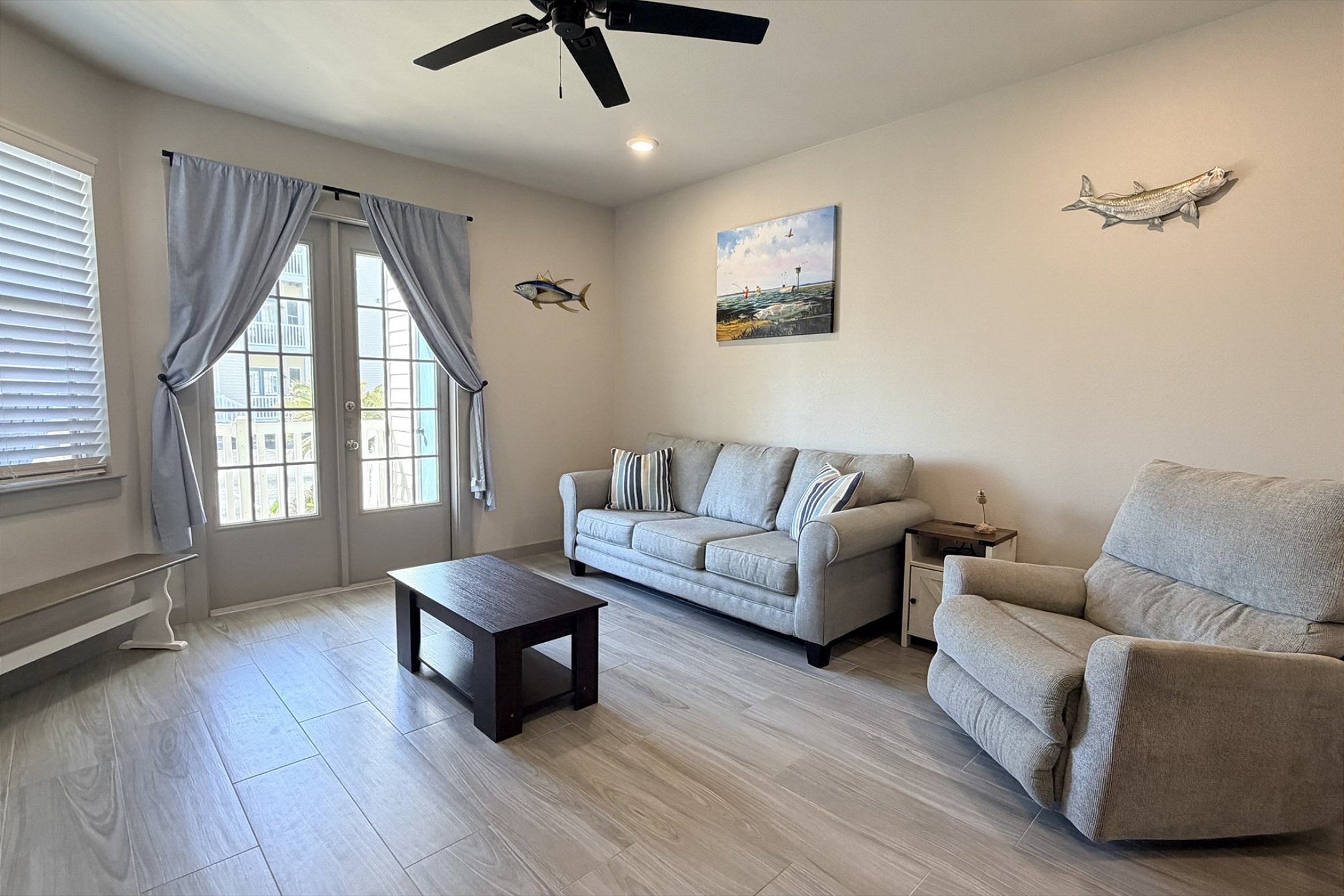Open living area with full size sleeper sofa, flat screen TV, and patio access