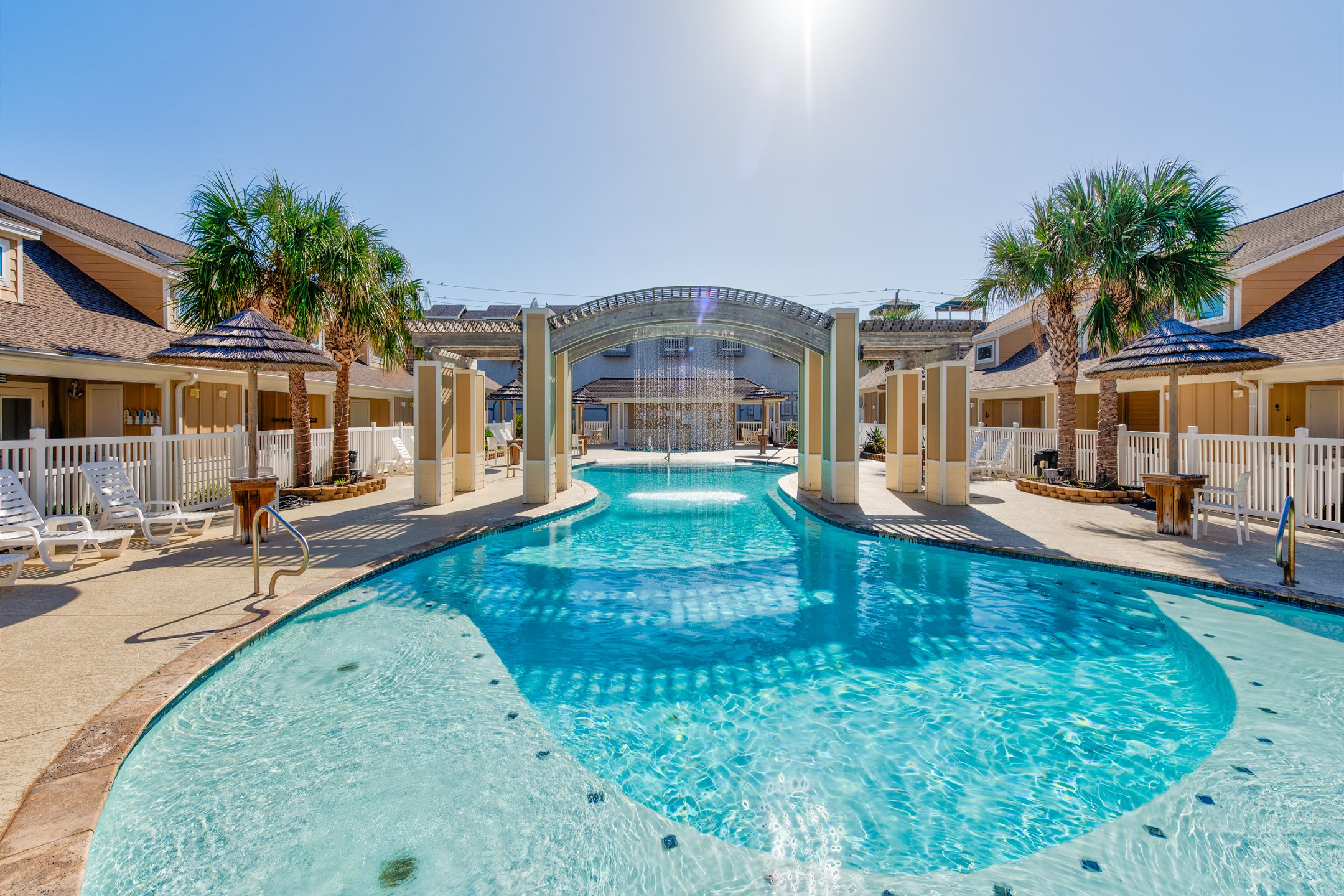 Experience ultimate relaxation at this crystal-clear pool complete with shaded seating and tropical vibes