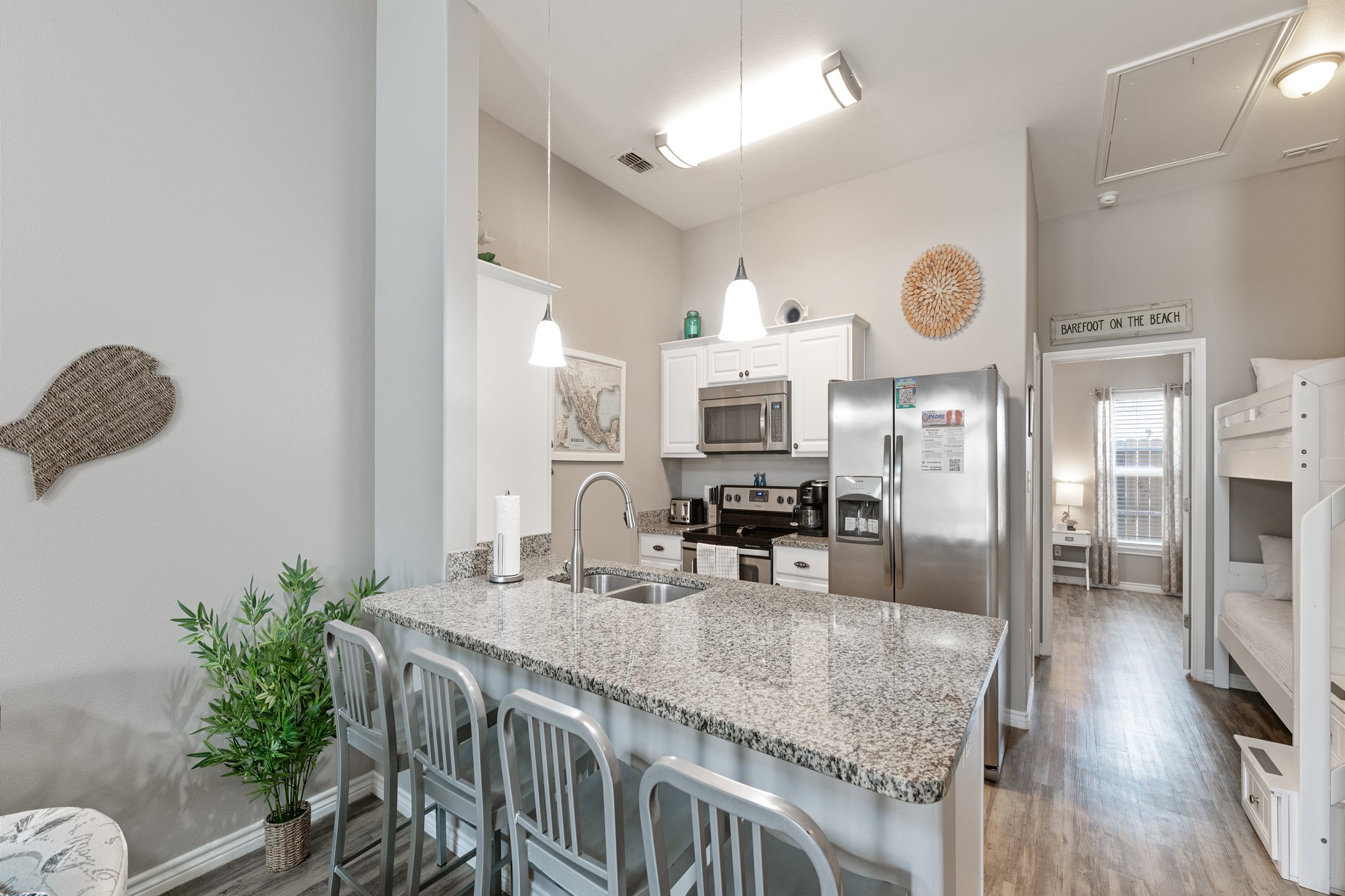 Kitchen area with breakfast bar that seats four and over looks the kitchen space to spend time with the family