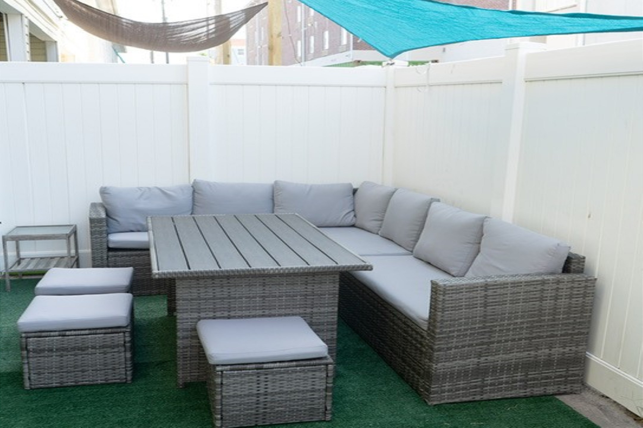 Back yard area with comfortable seating and artificial turf 