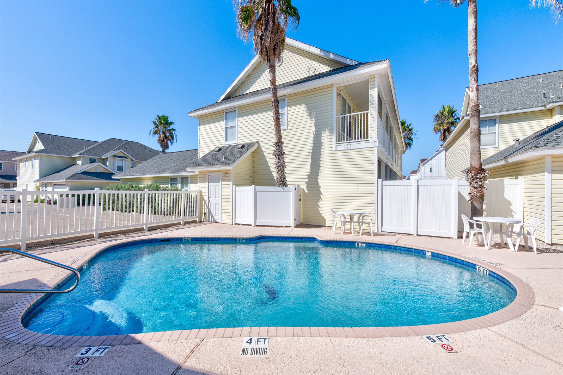 Sparkling pool with table and chairs to relax under the sun on your vacation