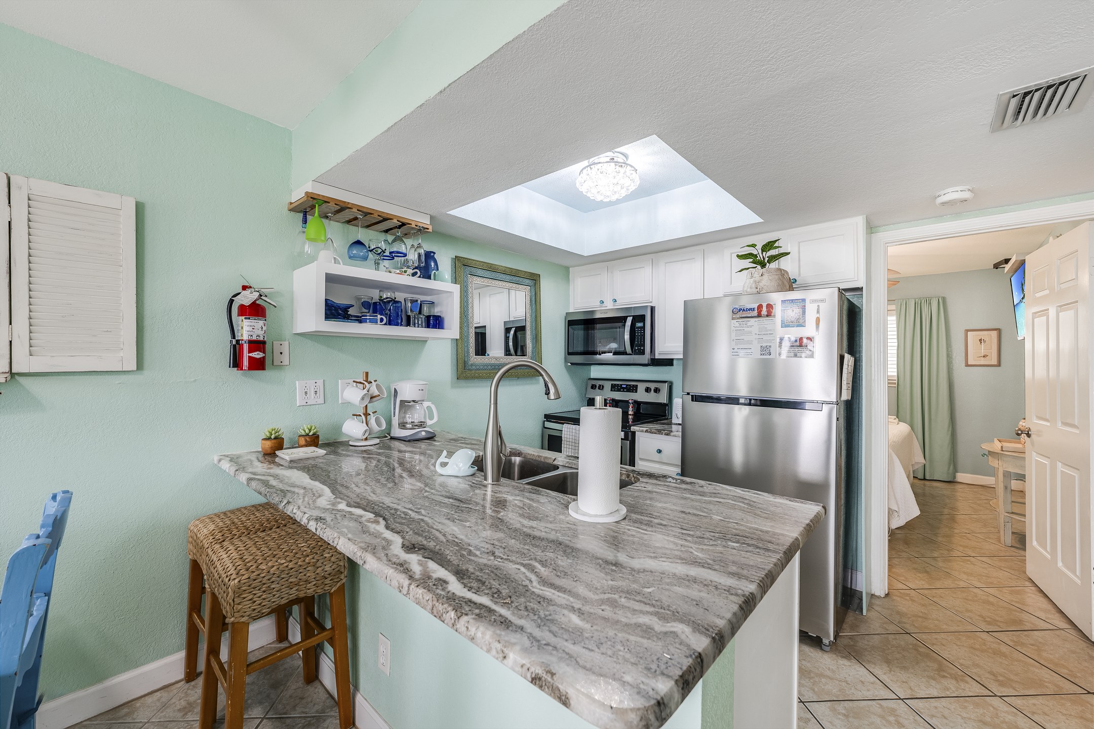 Breakfast bar and fully equipped kitchen with stainless steel appliances 