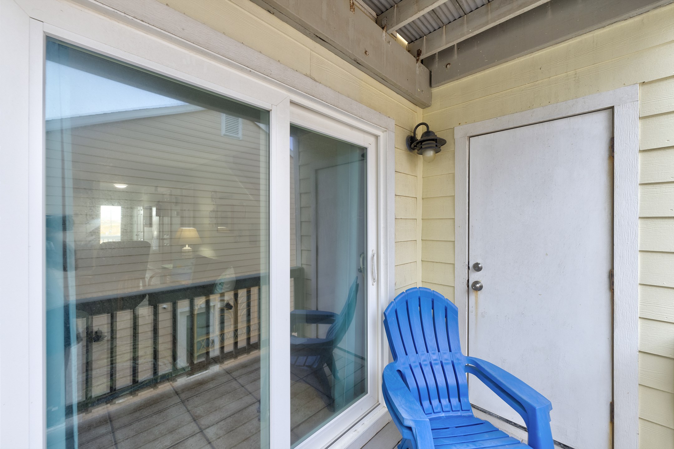 Private balcony off the living area with cozy chairs and views of the pool