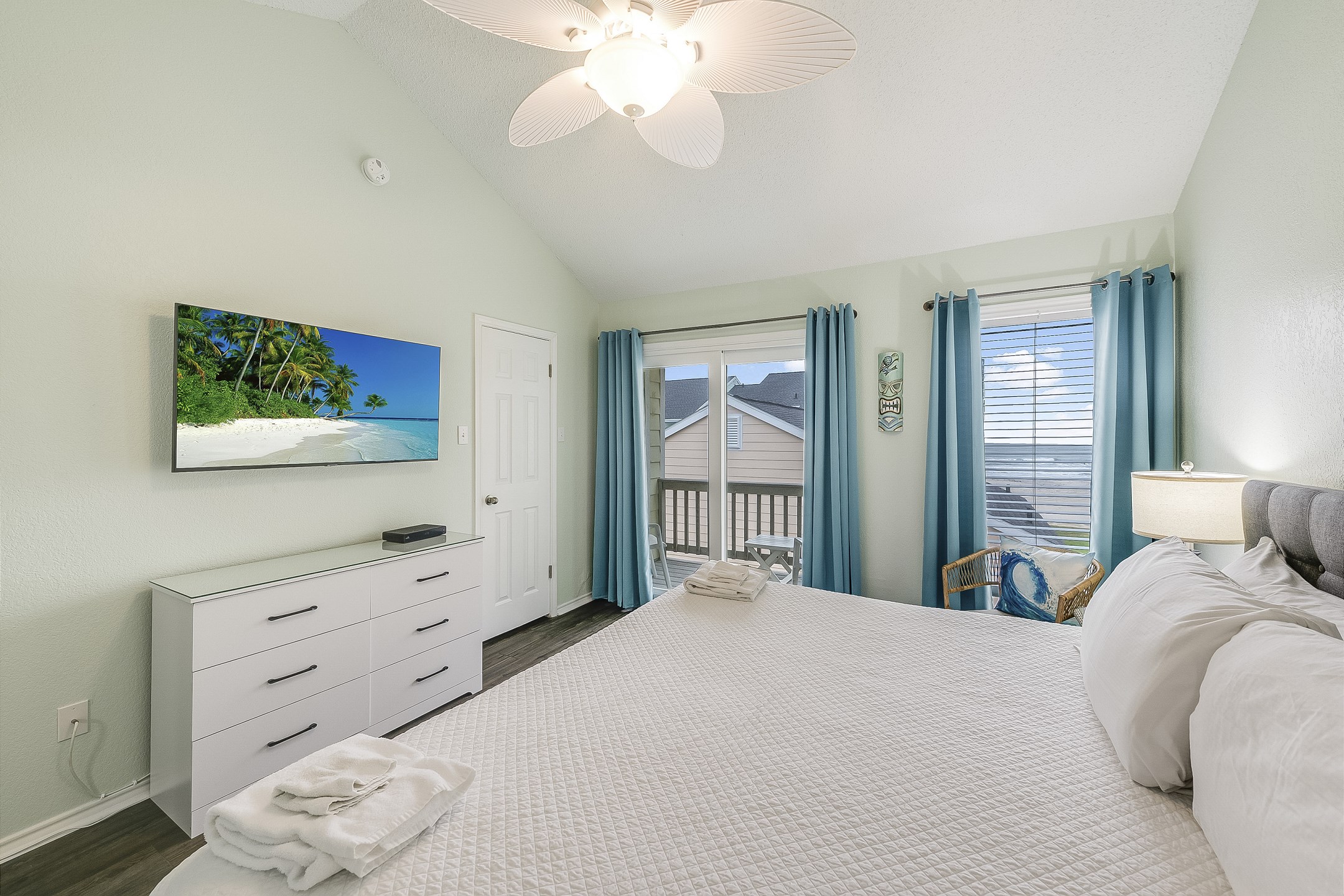 Primary bedroom on the second floor with king size bed, new headboard, flat screen TV, private bathroom and a lovely private balcony that offers unbeatable views of the ocean and pool 