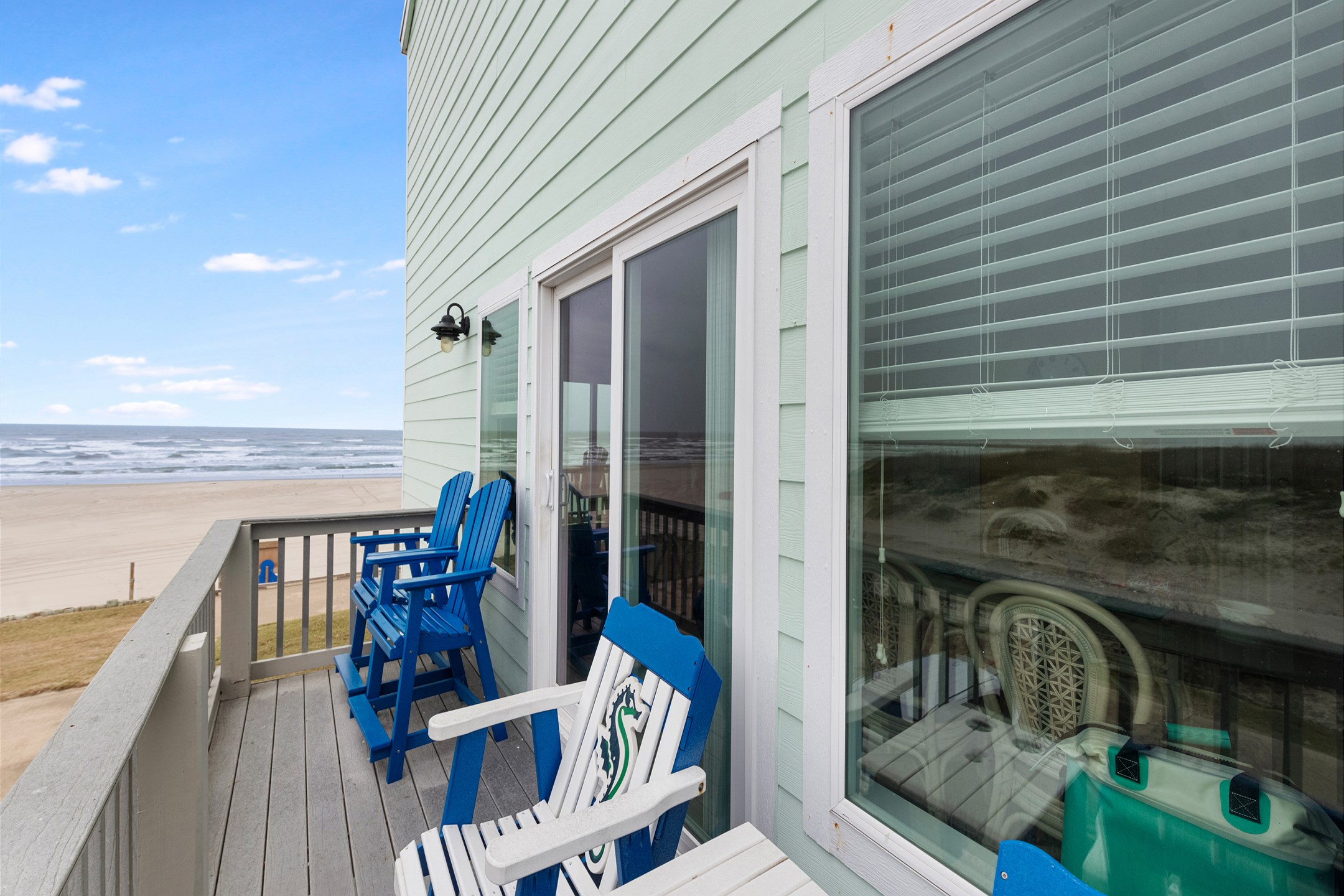 Scenic views of the beach from the second level balcony with comfortable chairs for relaxing