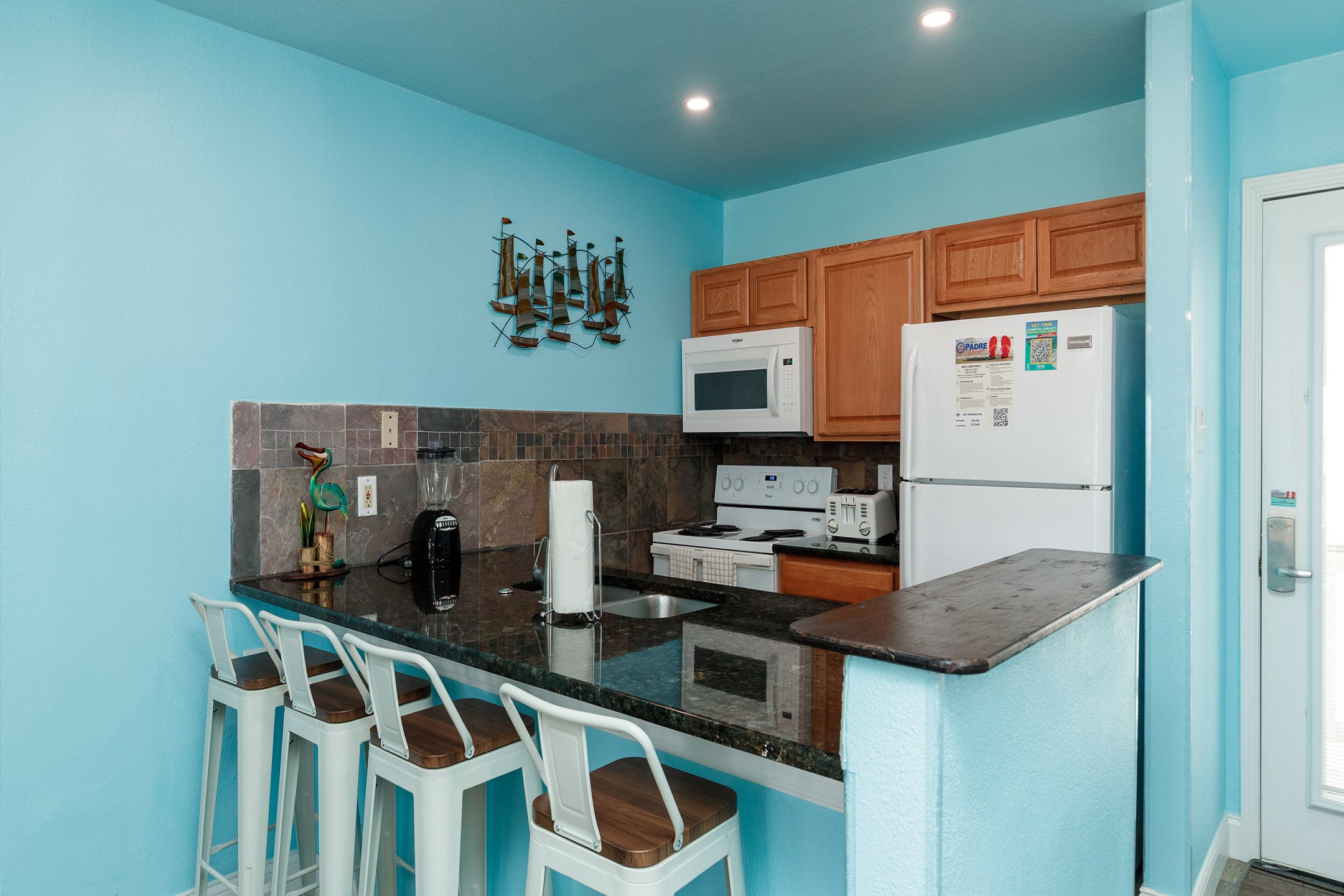 Kitchen area with breakfast bar that seats four to gather with the family while cooking 