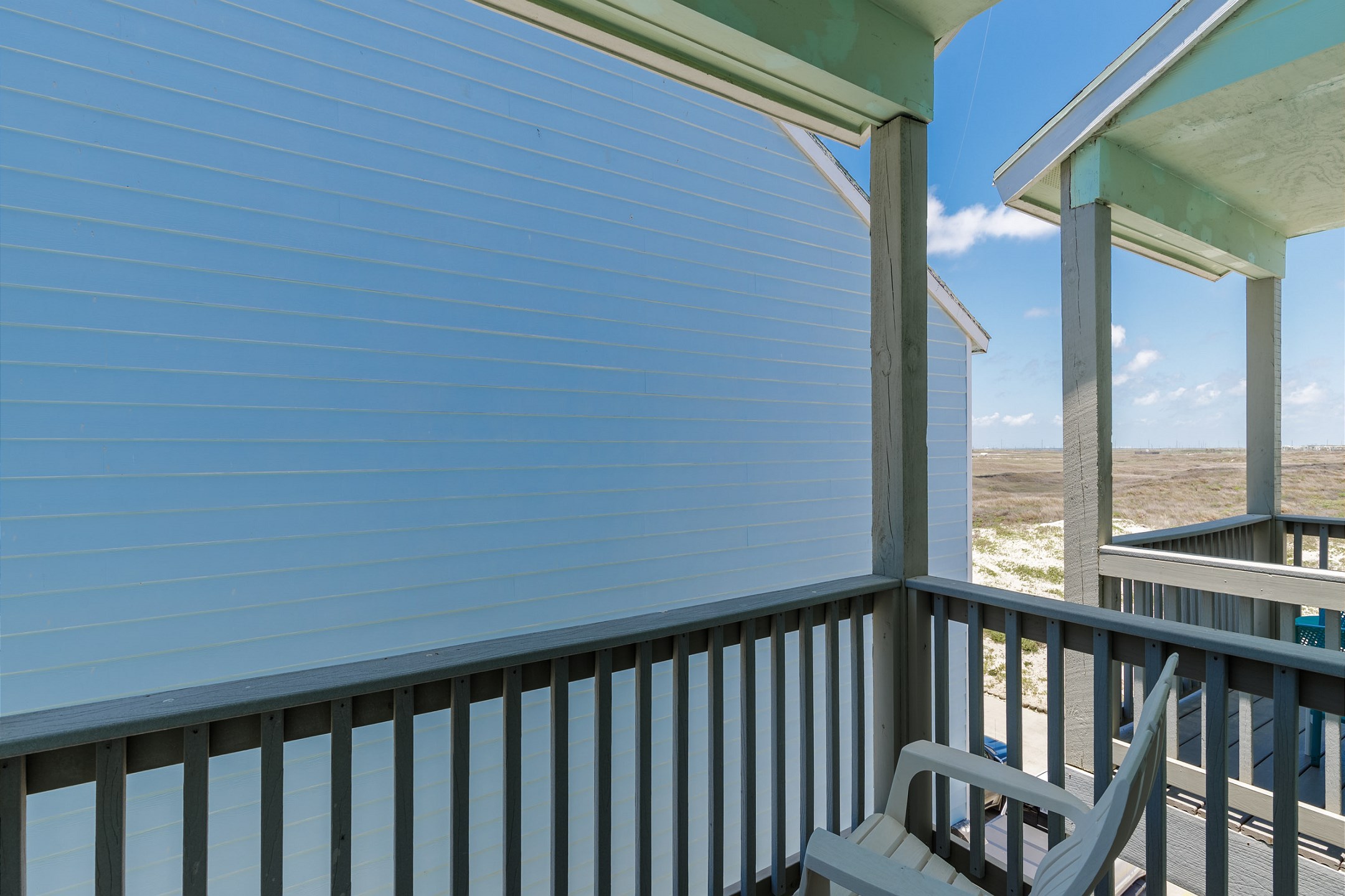 Private balcony off the second bedroom with seating and pool views