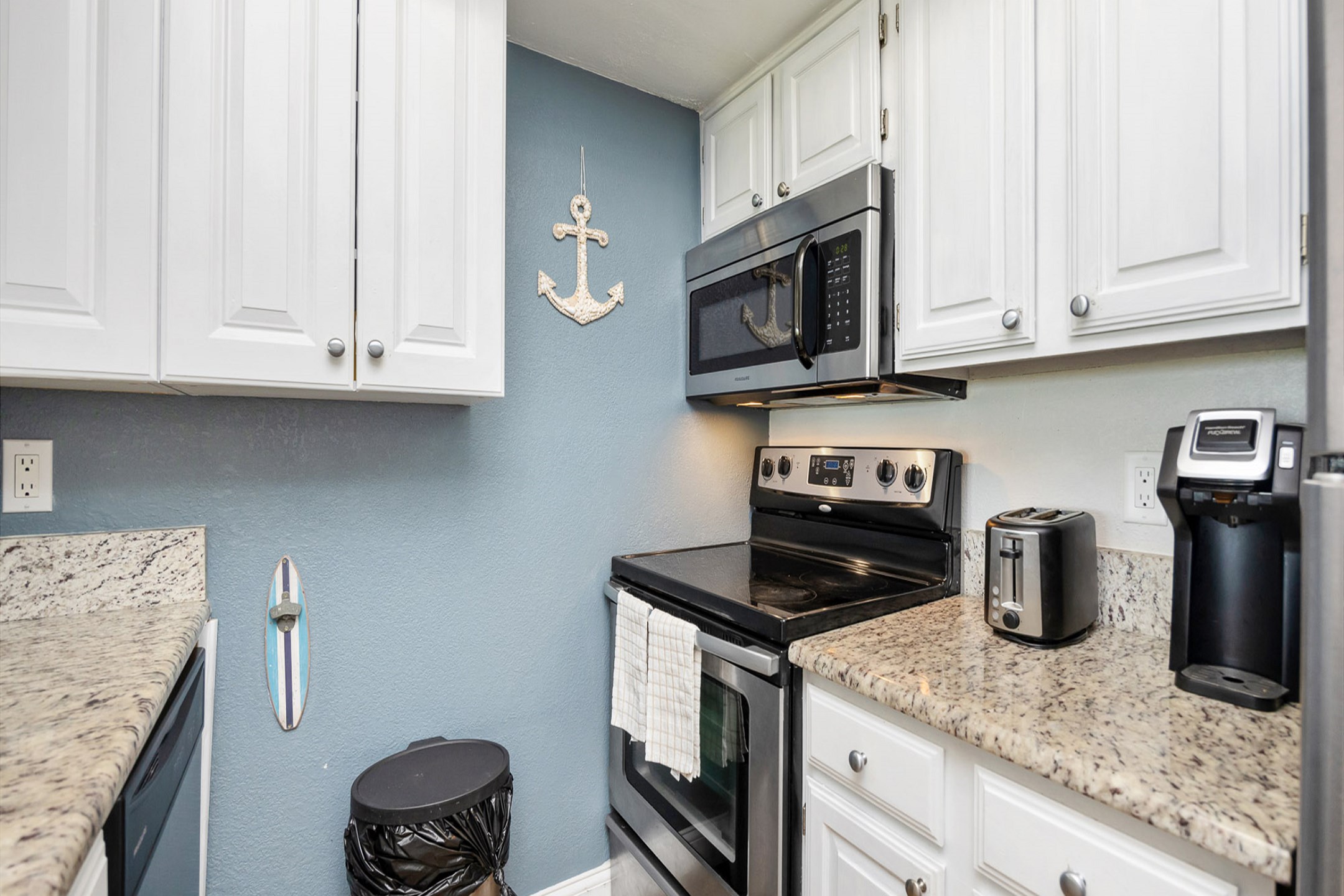 Fully equipped kitchen with coffee maker, toaster, cookware, dinnerware, and other kitchen essentials provided