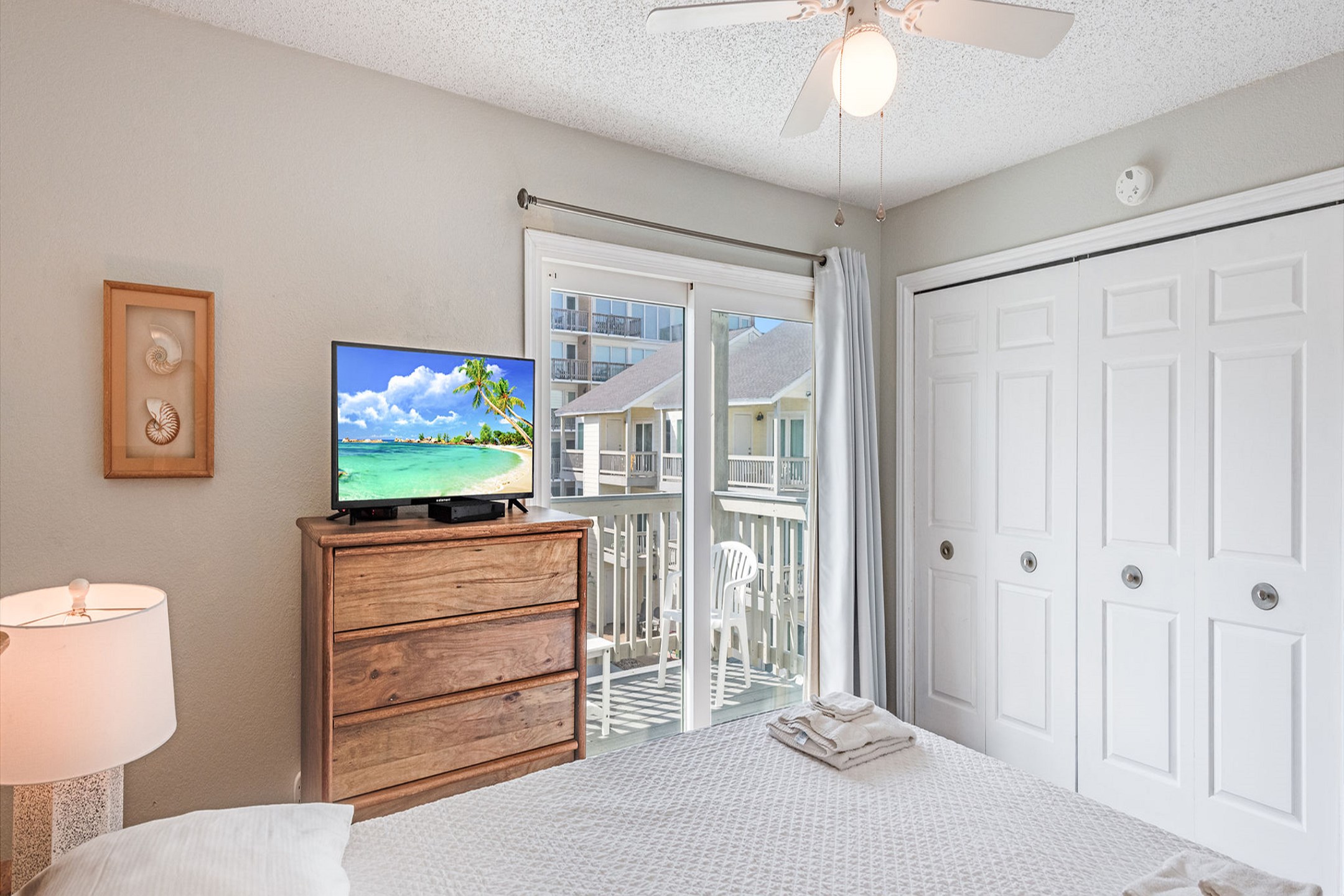 Second bedroom with queen size bed, private balcony, and flat screen TV