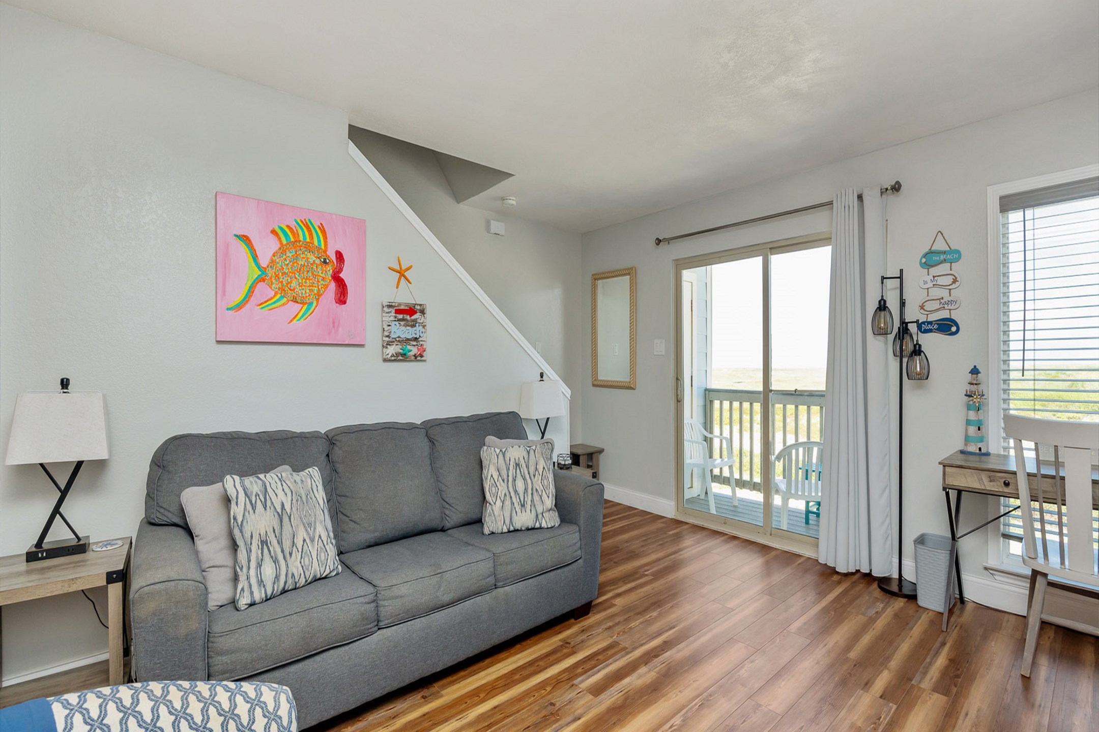 Open concept living area with private balcony access, queen size sleeper sofa, and flat screen TV 