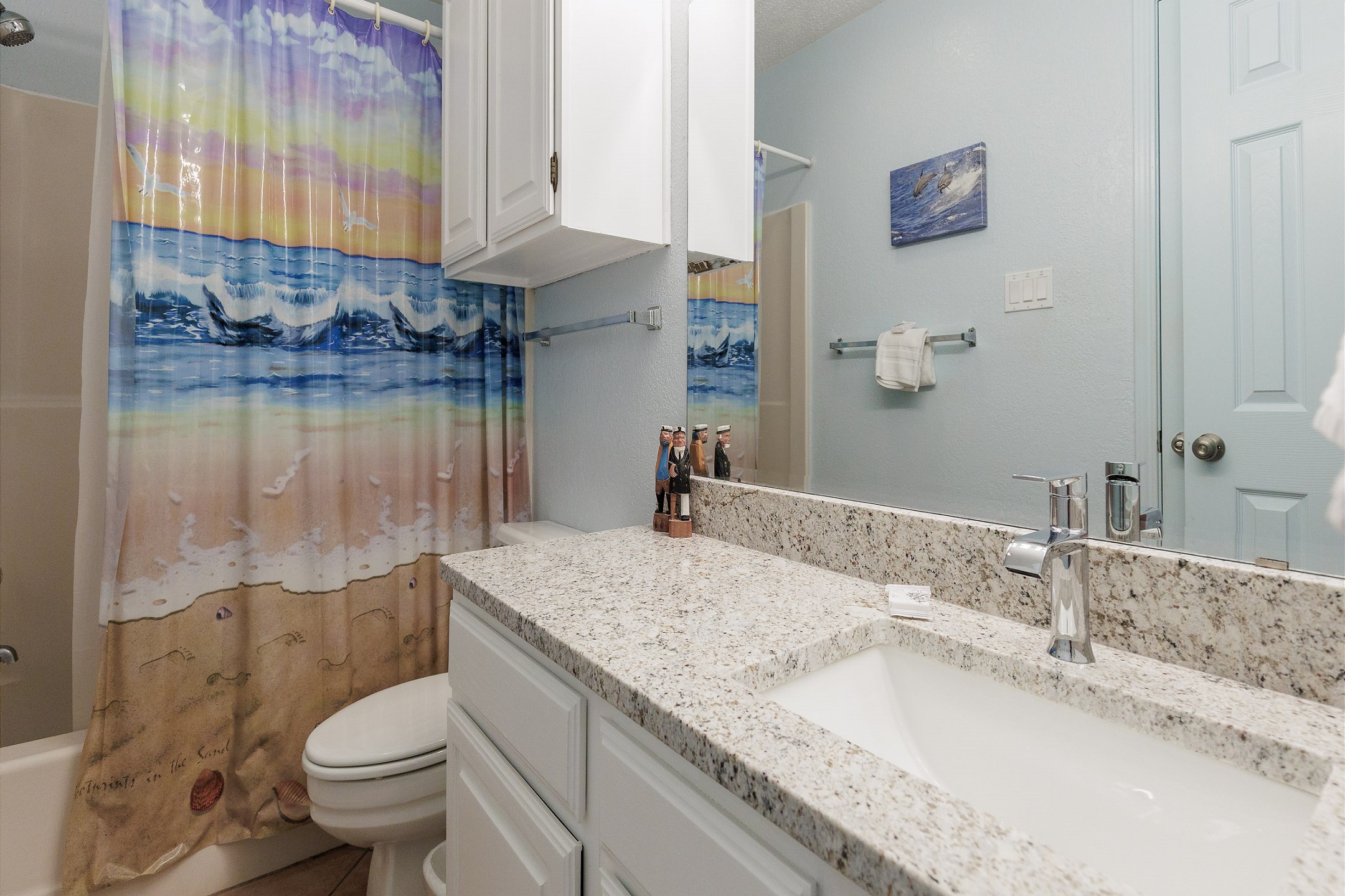Guest bathroom featuring toilet, sink, and tub/shower combo
