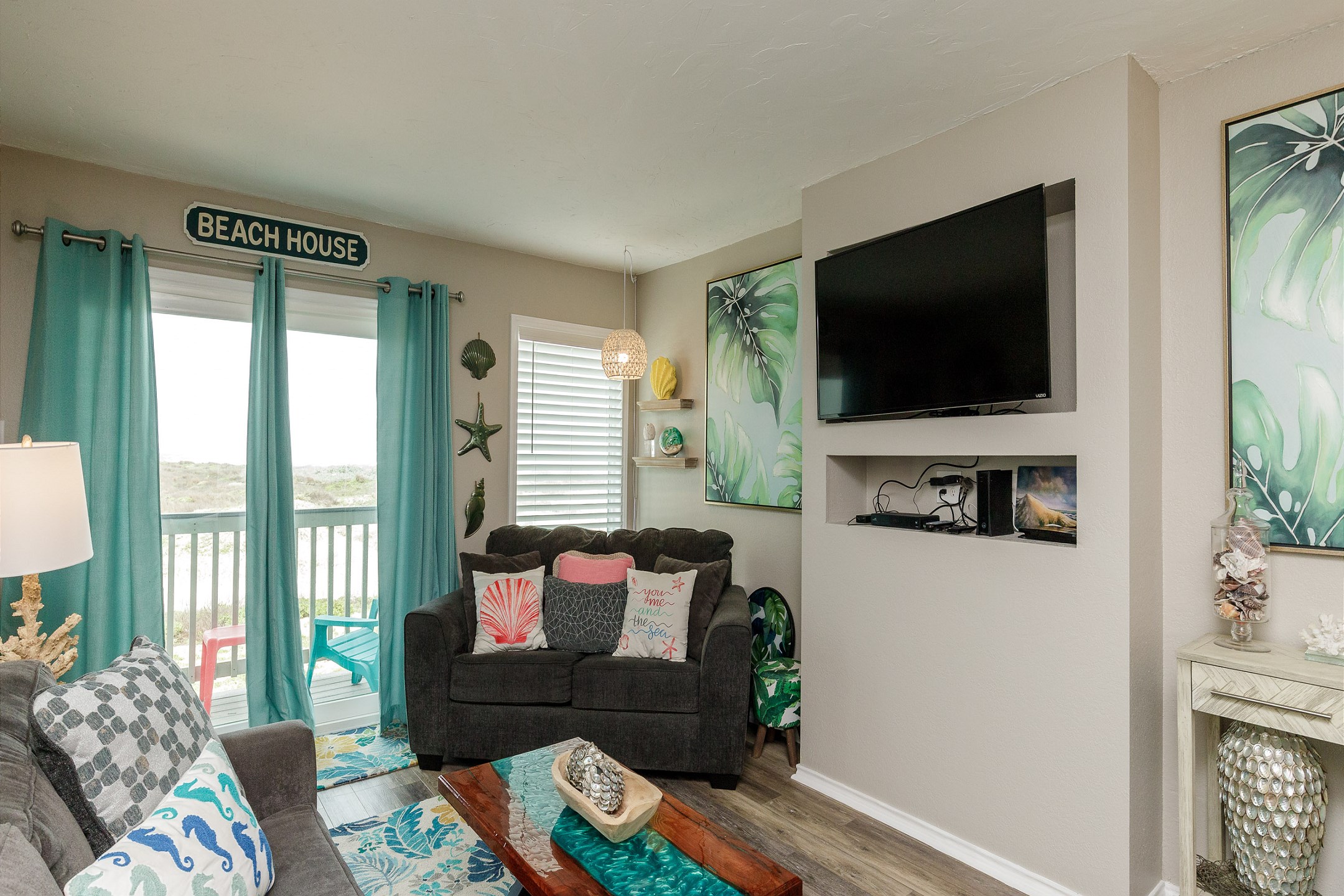 Living area with flat screen TV and access to the private balcony 
