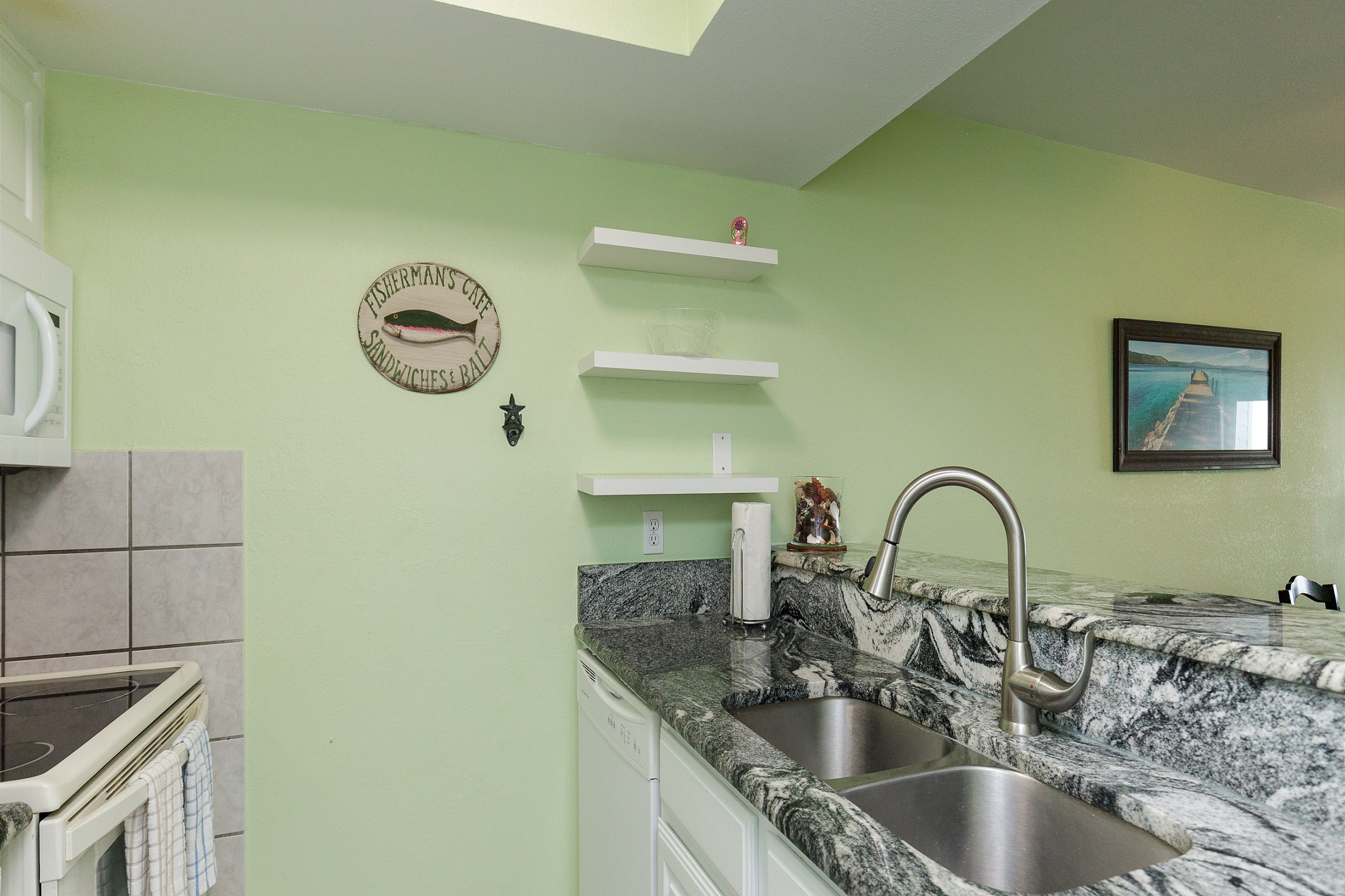 Sleek modern kitchen boasting granite countertops and ample space for preparing a full meal