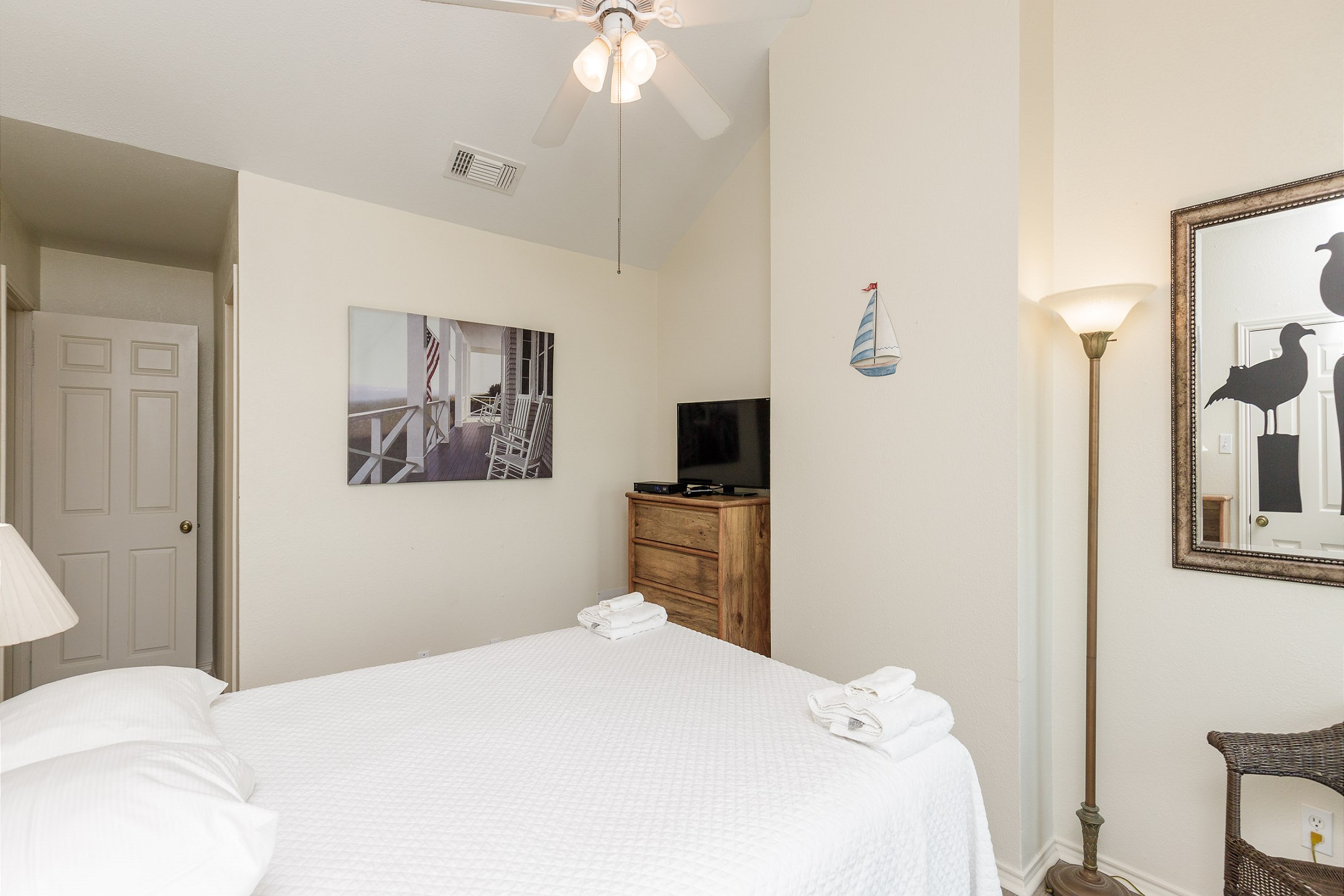 Second floor master bedroom with a queen size bed, private balcony, and ensuite bathroom