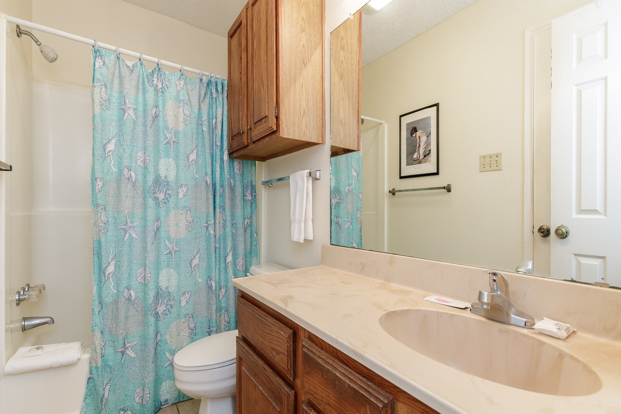 Guest bathroom with a toilet, sink, and a combination tub/shower