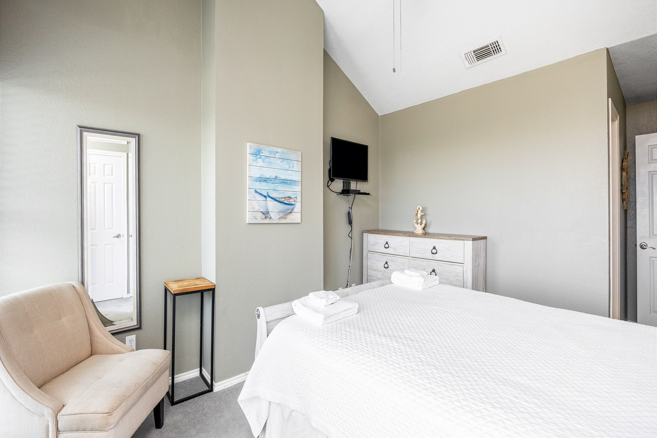 Master bedroom on the second floor with queen size bed, ensuite bathroom, flat screen TV and access to a private balcony with beach view