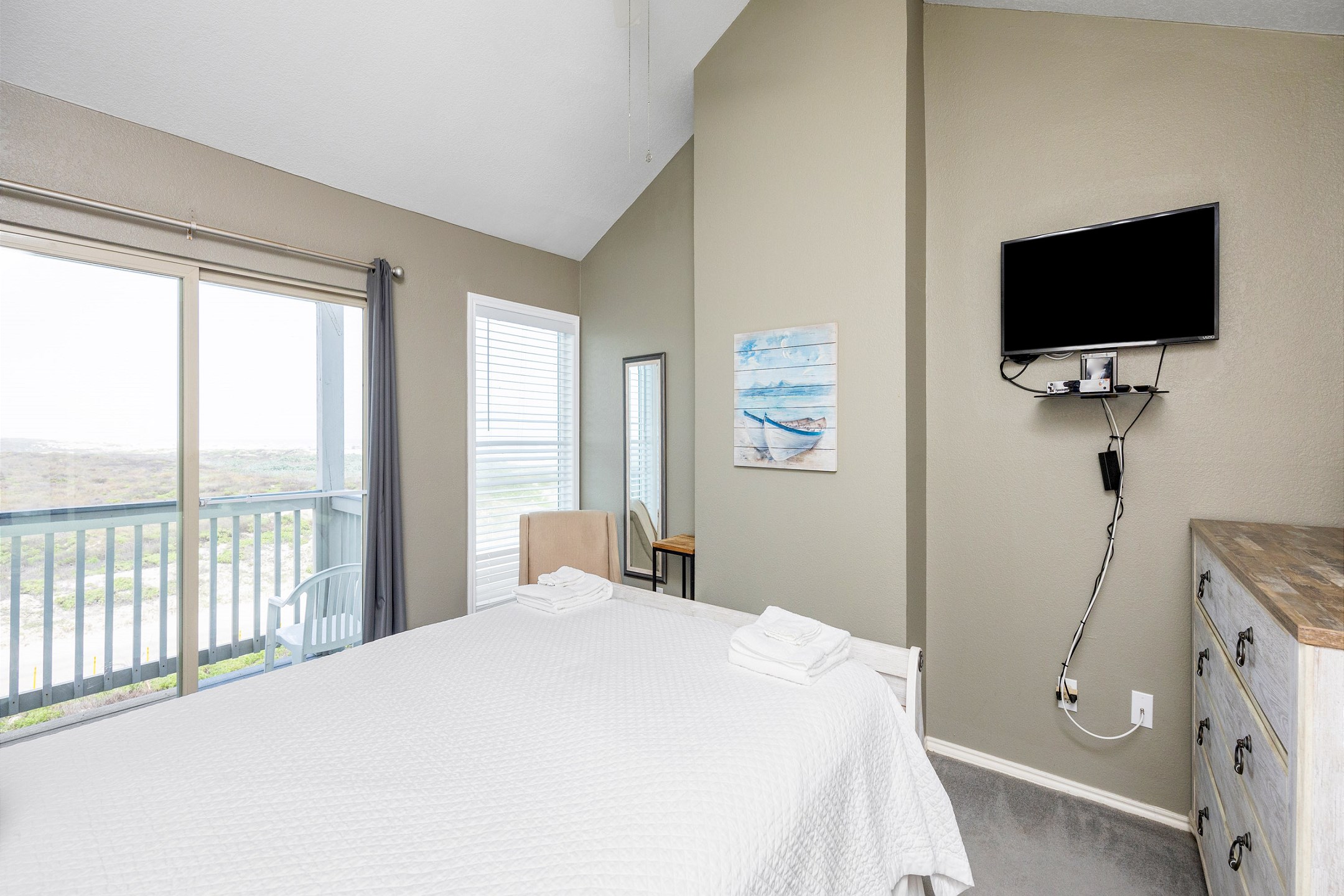 Master bedroom on the second floor with queen size bed, ensuite bathroom, flat screen TV and access to a private balcony with beach view