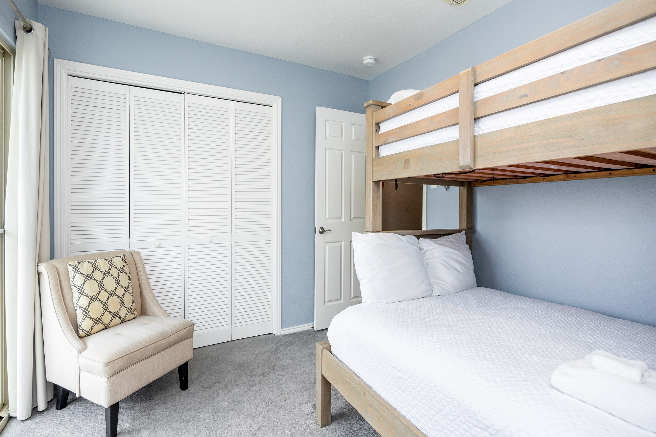 Guest bedroom on the second floor with a twin over full bunk bed, private balcony, and flat screen TV
