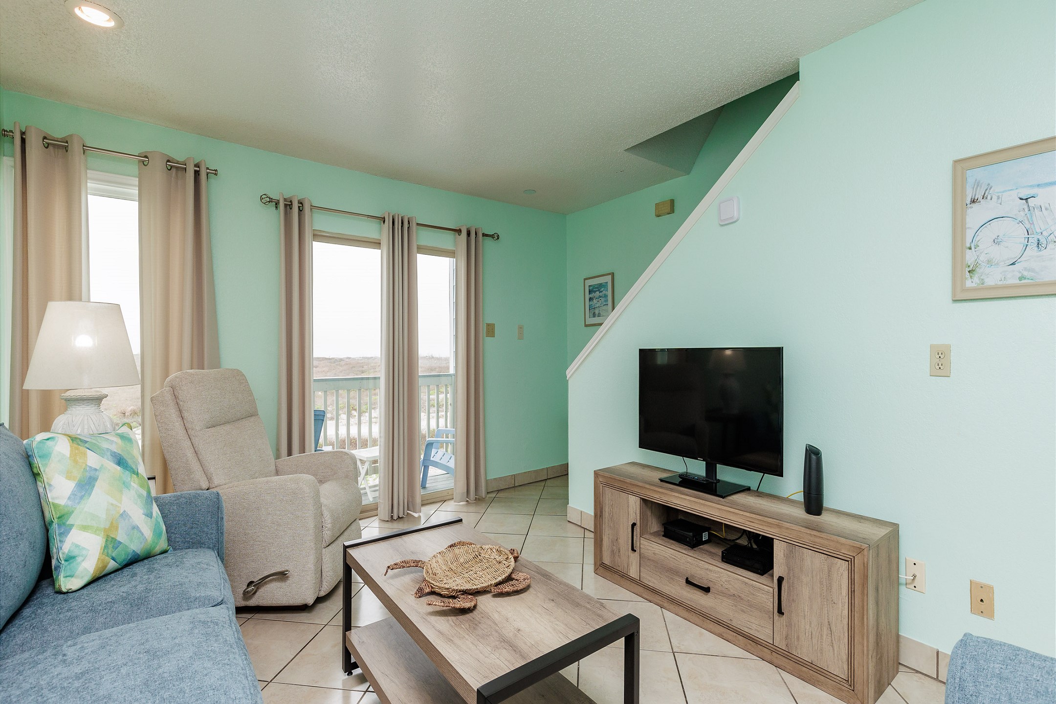 Cozy living area with flat screen TV, a great view, and stairs leading to the second floor bedrooms 