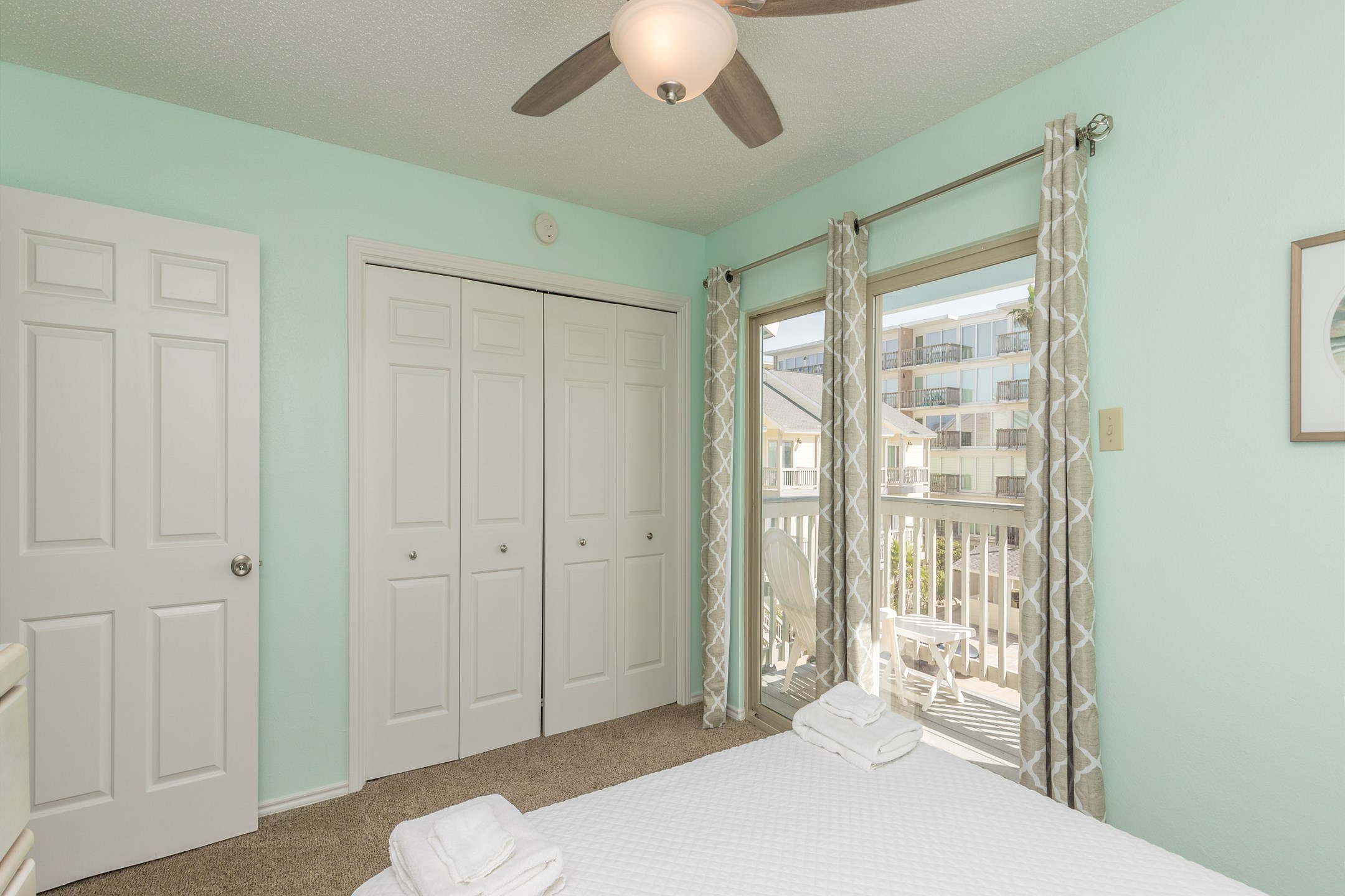 Guest bedroom on the second floor with queen size bed, flat screen TV, and private balcony 