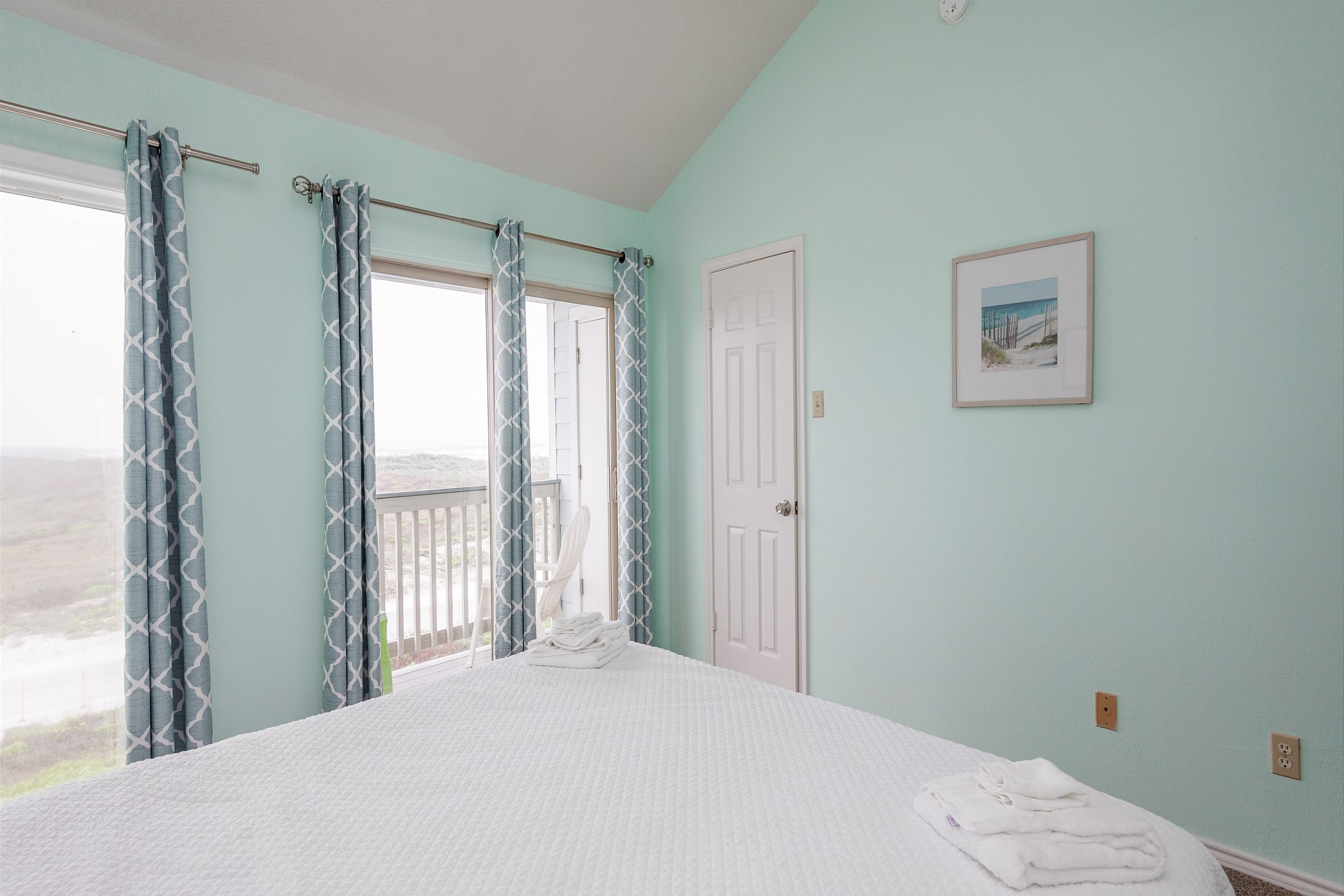 Master bedroom on the second floor with king size bed, private balcony, and ensuite bathroom
