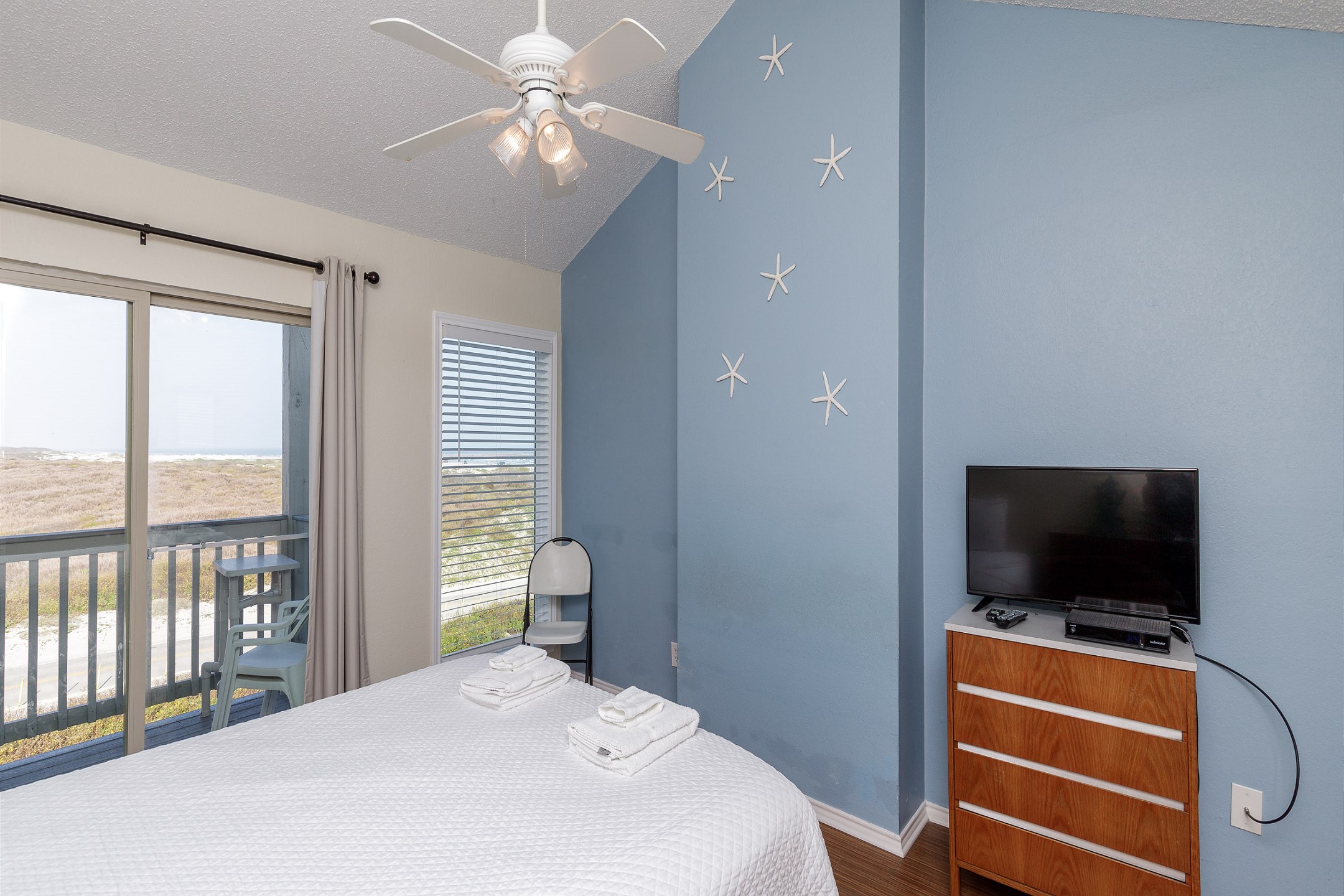 Master bedroom on the second floor with full size bed, flat screen TV, and private balcony 