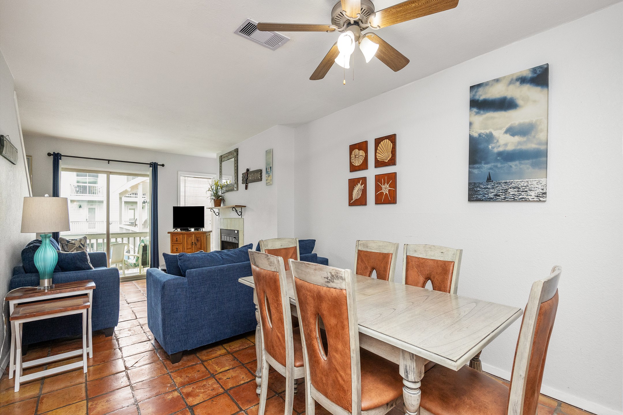 Dining area with seating for six that opens up into the living space, offering natural light shinning in 