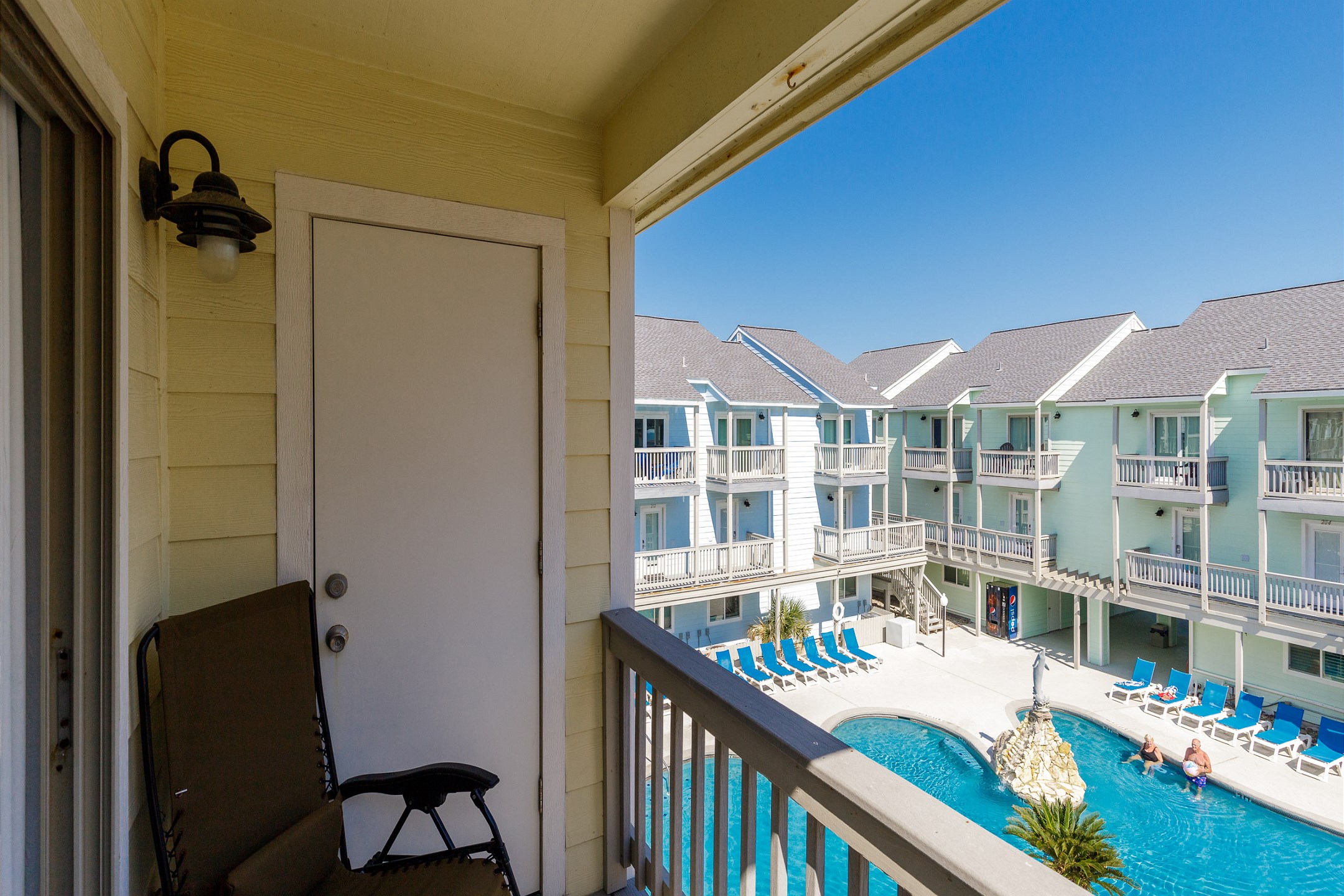 Private balcony from master bedroom with chairs that over looks the pool