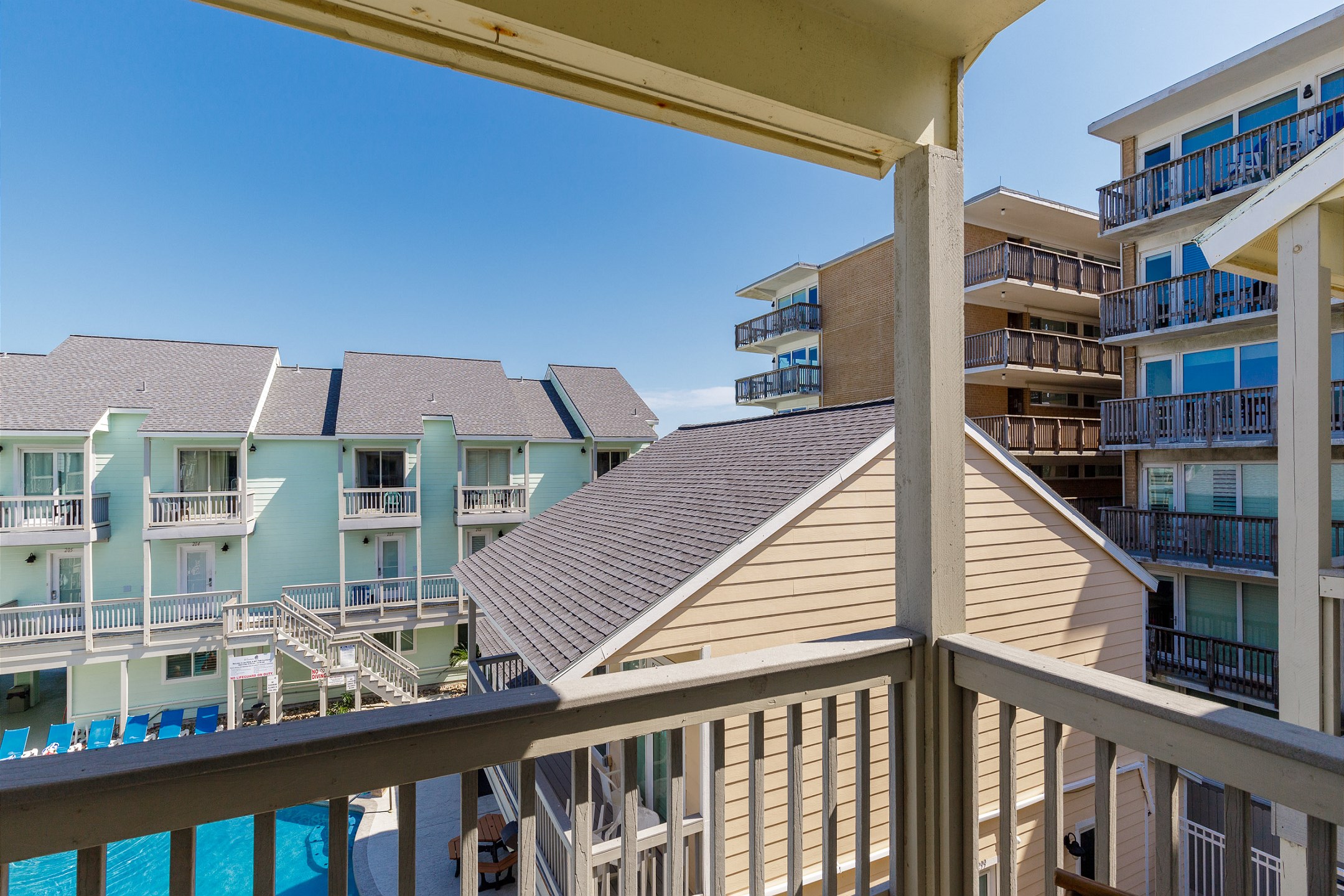 Private balcony from master bedroom with chairs that over looks the pool