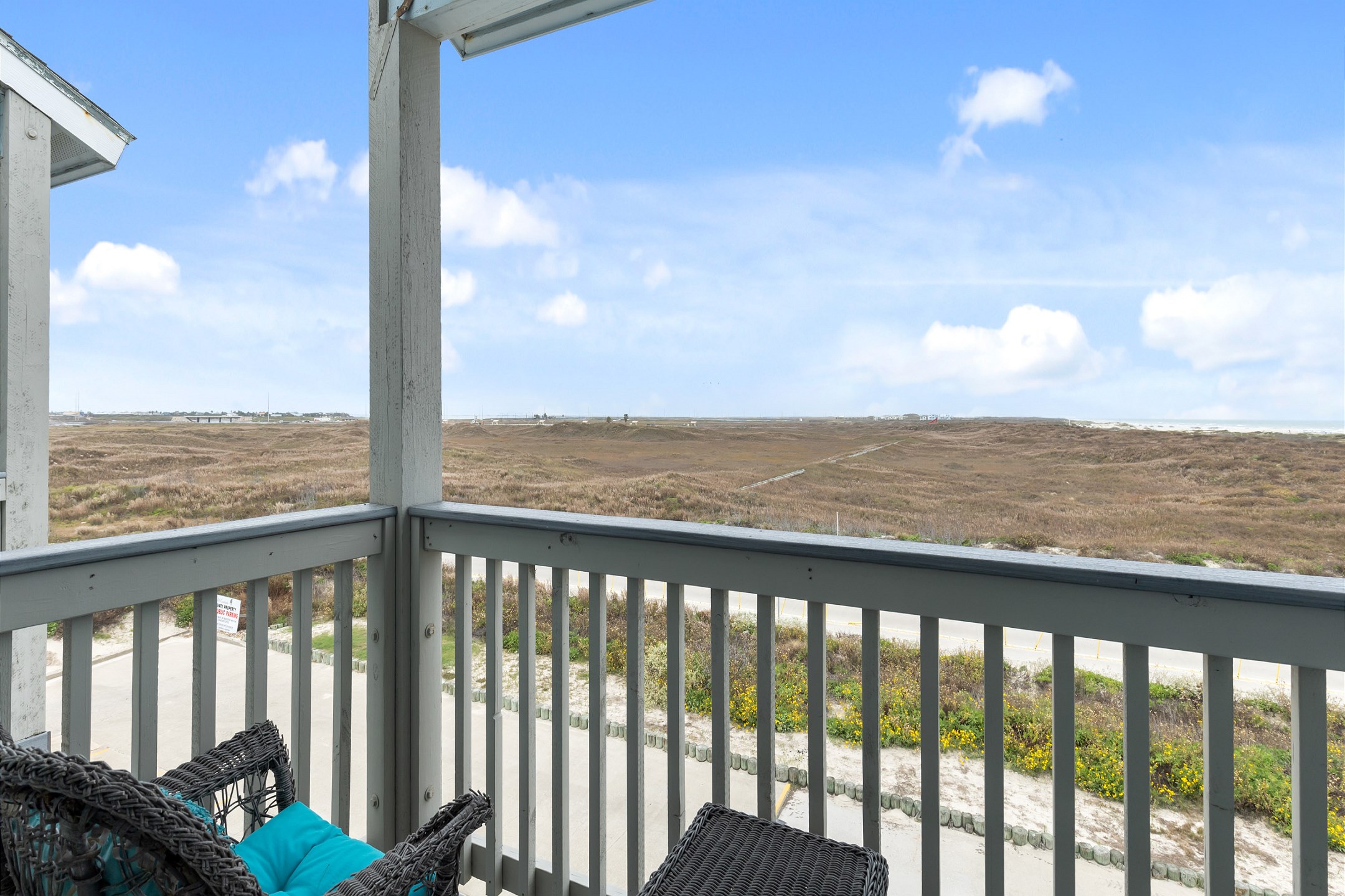 Private balcony off the master bedroom with chairs and dune view