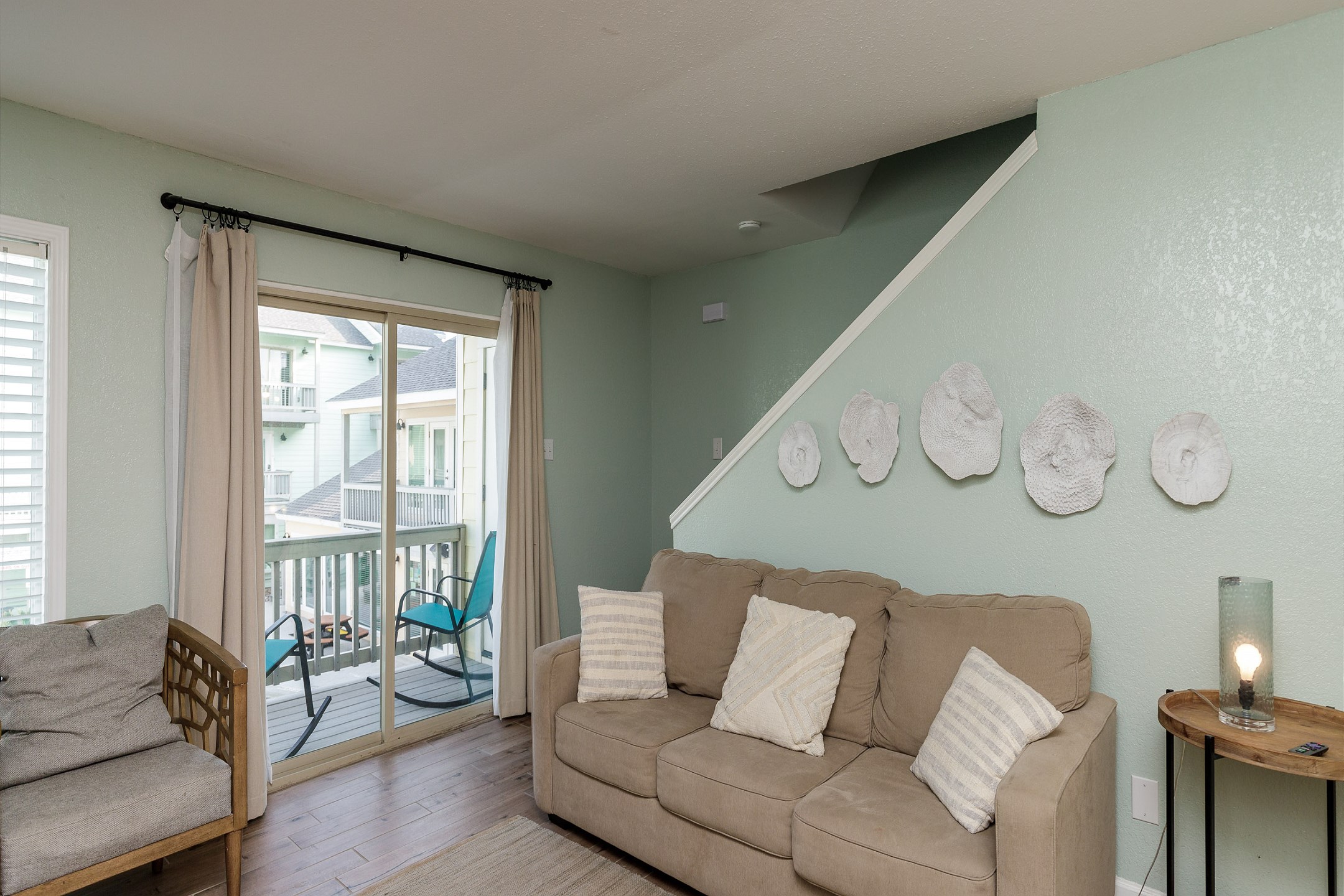 Bright living space with cozy furniture and private balcony that over looks the pool and offers comfortable chairs to relax 