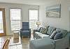 Living area with new furniture and a beautiful view of the beach from the large windows