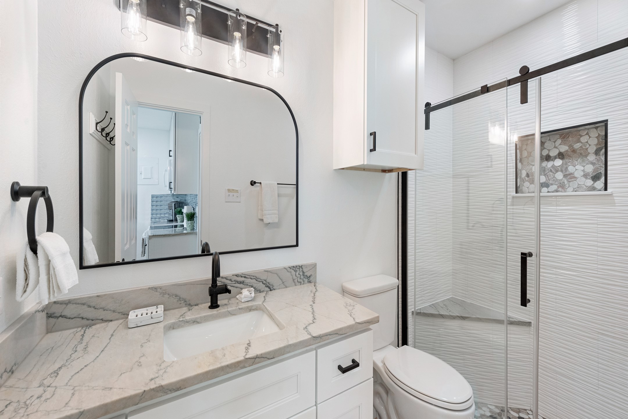 Remodeled bathroom with new cabinets, counter tops and beautiful walk in shower with pebble features 