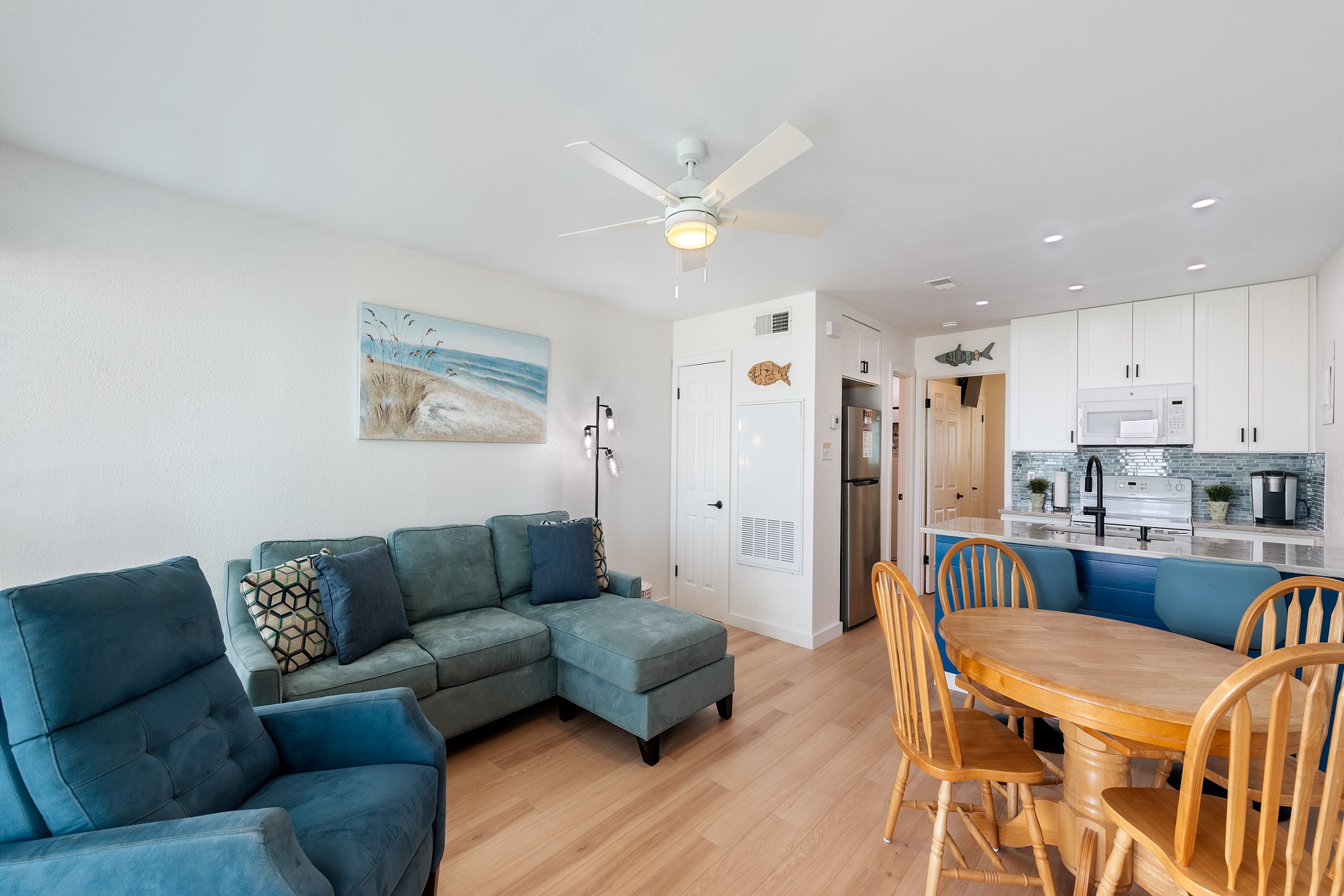 Spacious living area with cozy furniture, bright light shining in and new features throughout 