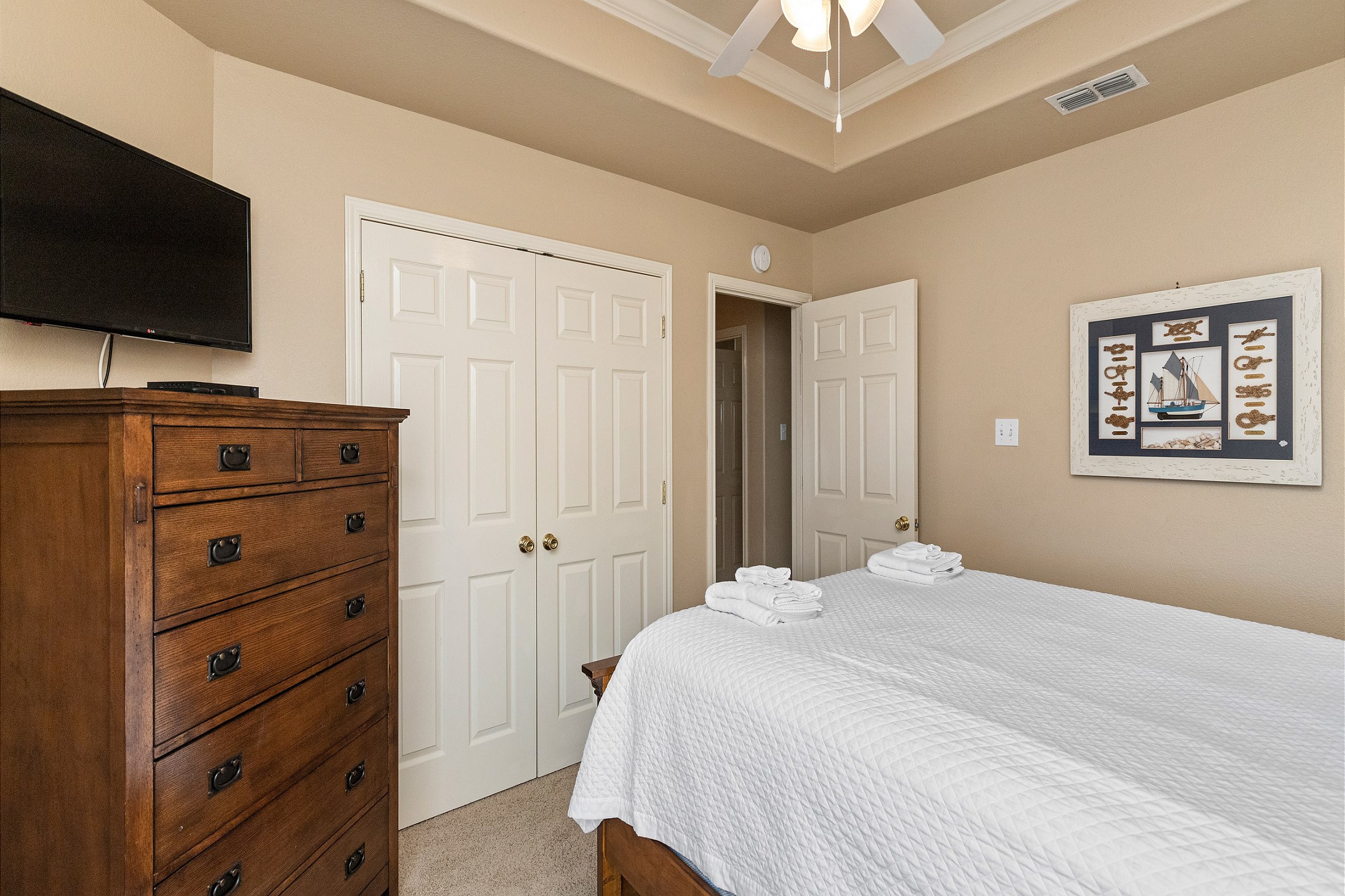 Second floor guest bedroom with queen size bed and mounted TV