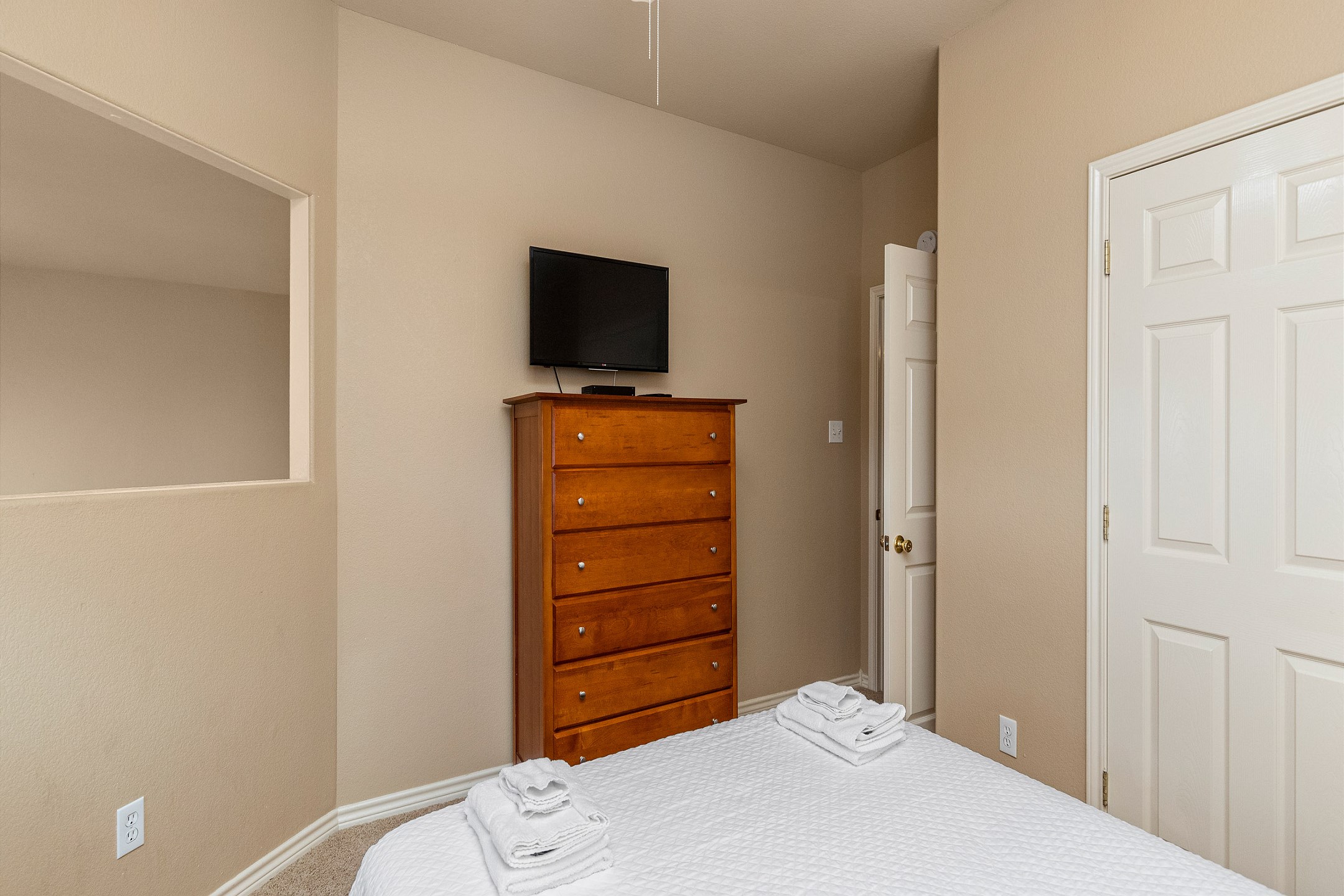 Second floor guest bedroom with queen size bed and mounted TV