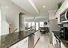 Open concept kitchen area with stainless steel appliances and large island 
