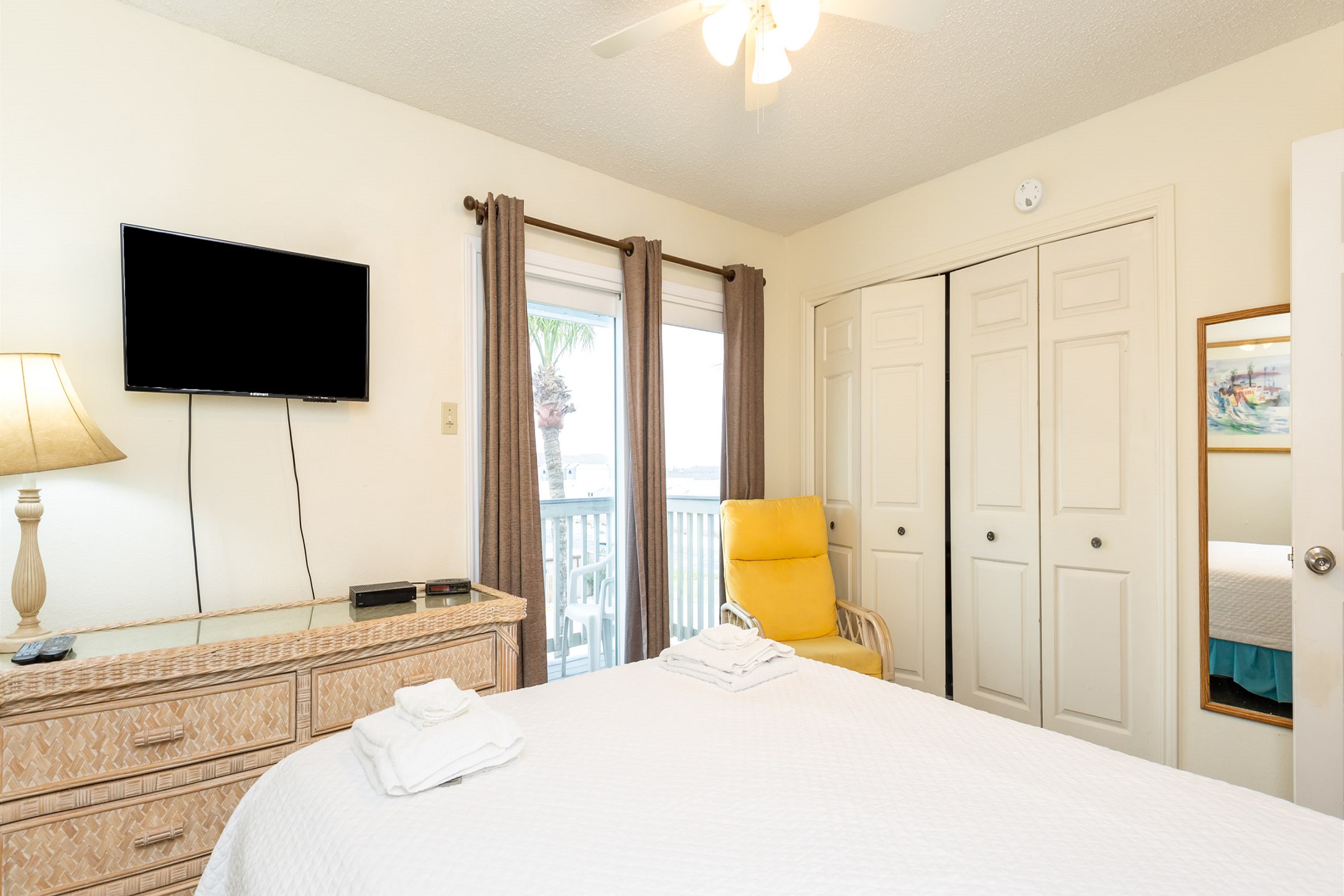 Second bedroom on the second floor with a queen size bed, private balcony, and flat screen TV