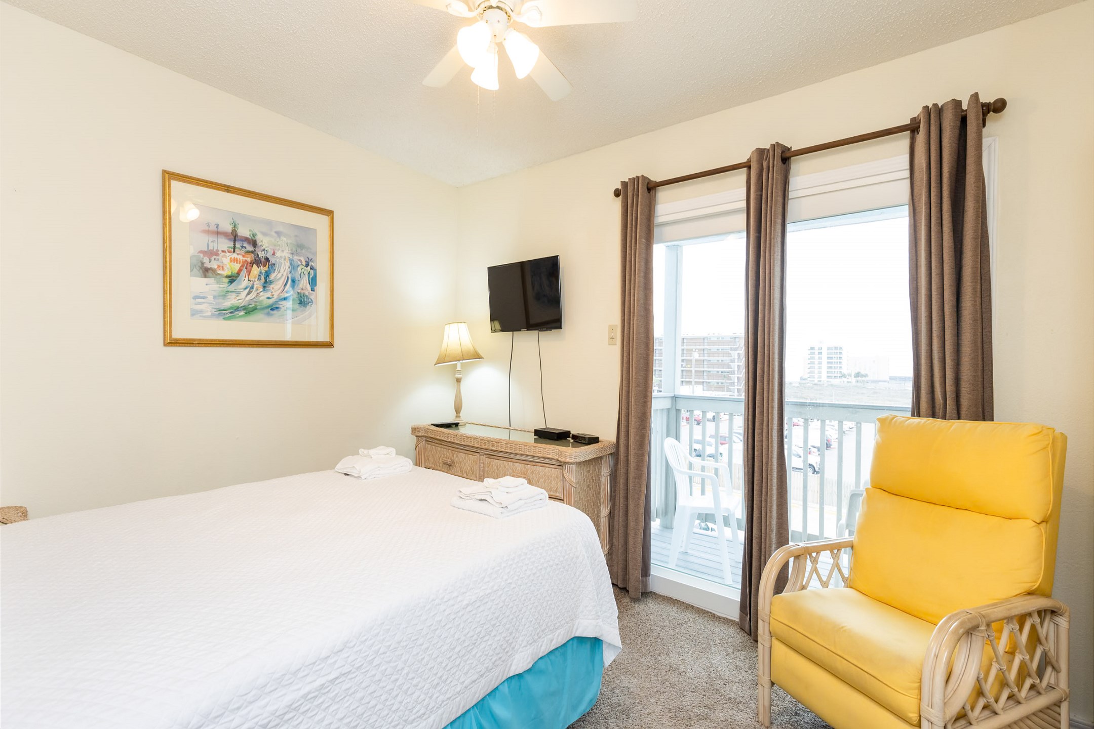 Second bedroom on the second floor with a queen size bed, private balcony, and flat screen TV