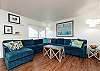 Updated living space with cozy sofa and bright light shinning in 