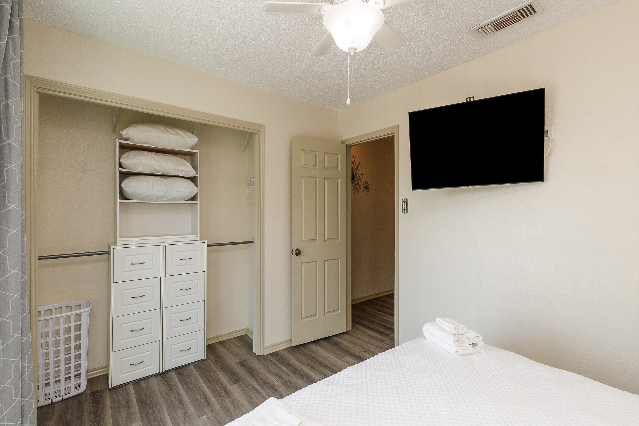 Master bedroom with queen size bed, flat screen TV, and private balcony