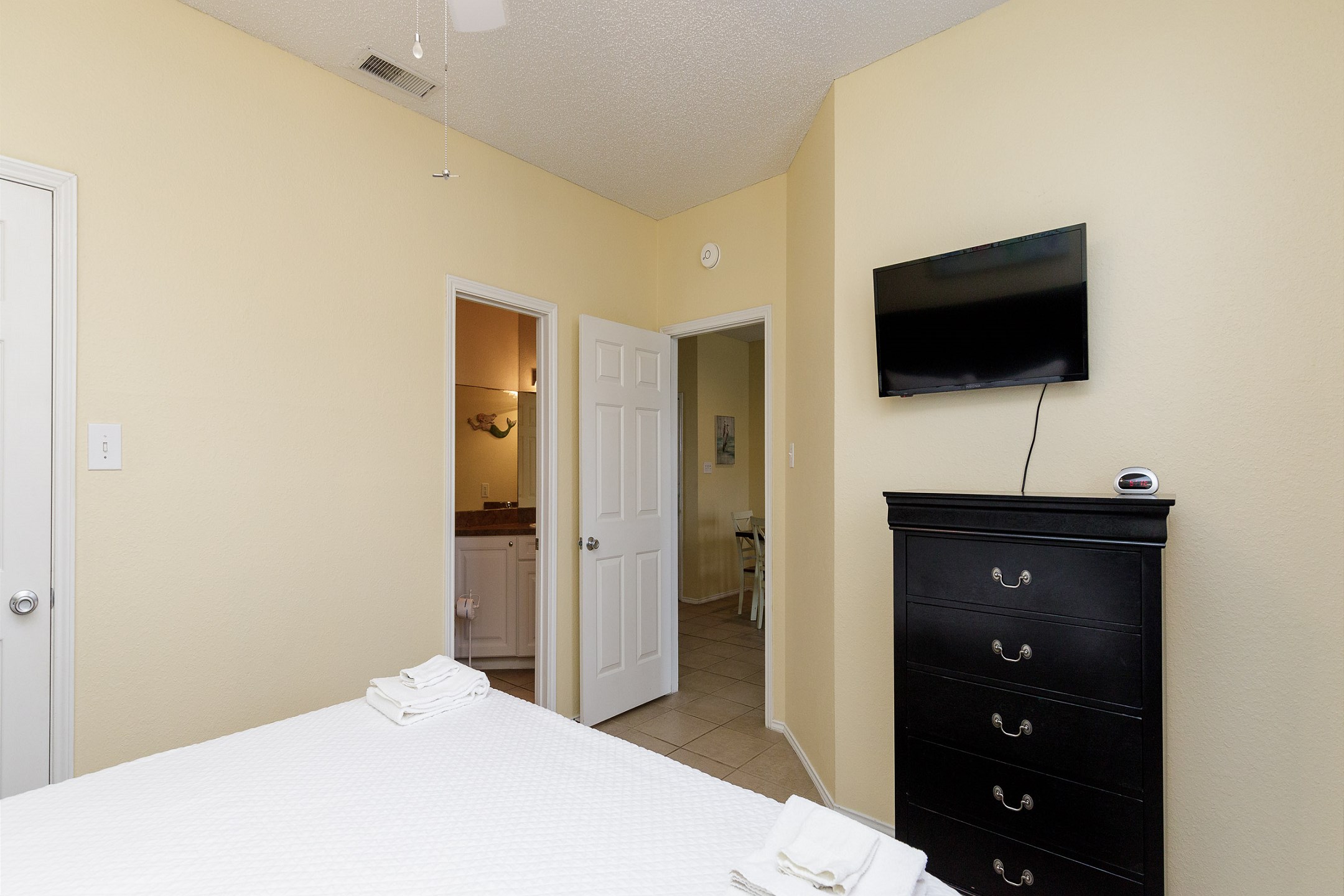 Master bedroom with king size bed, private bathroom, and mounted TV