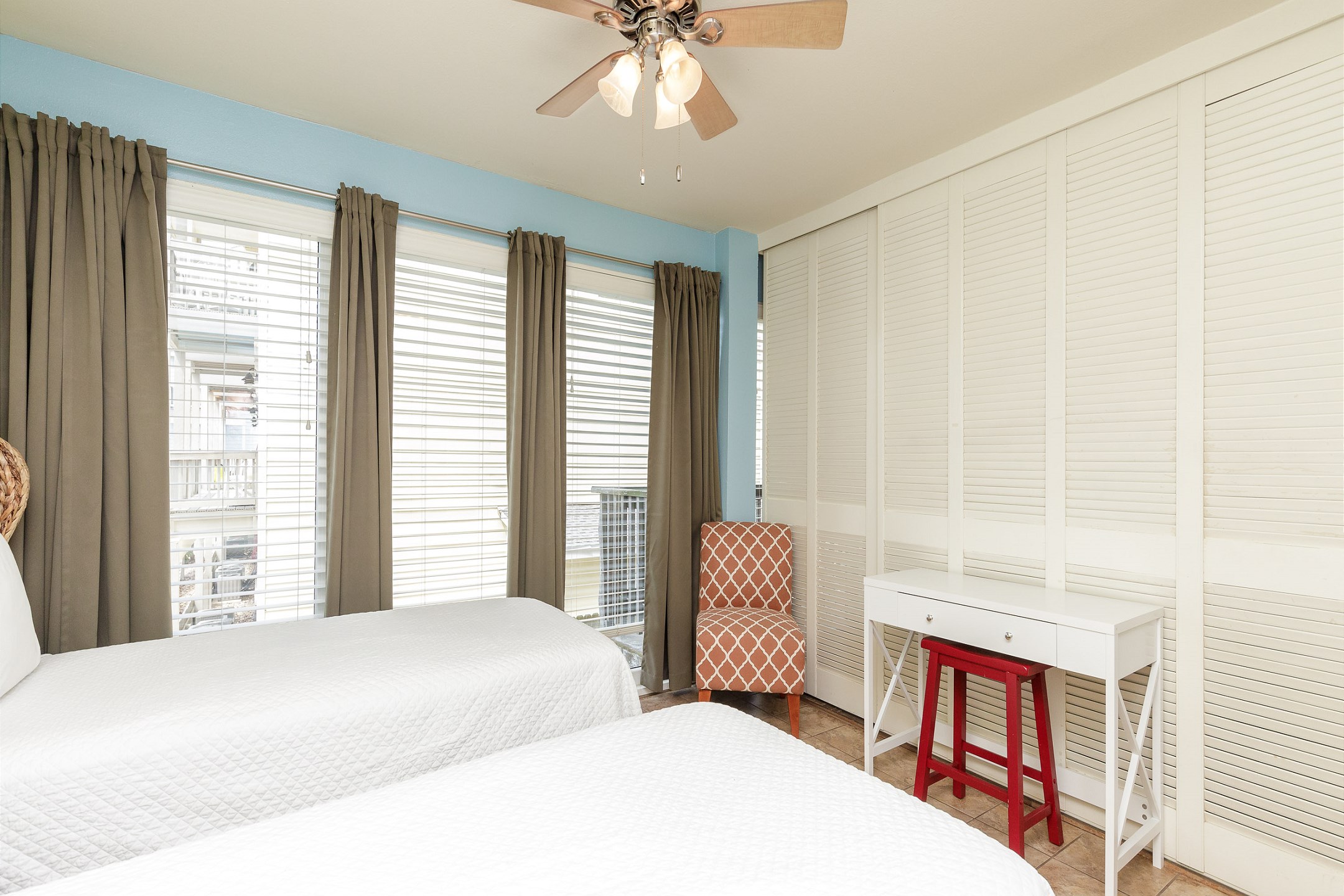 Second bedroom with two twin beds and a small desk 