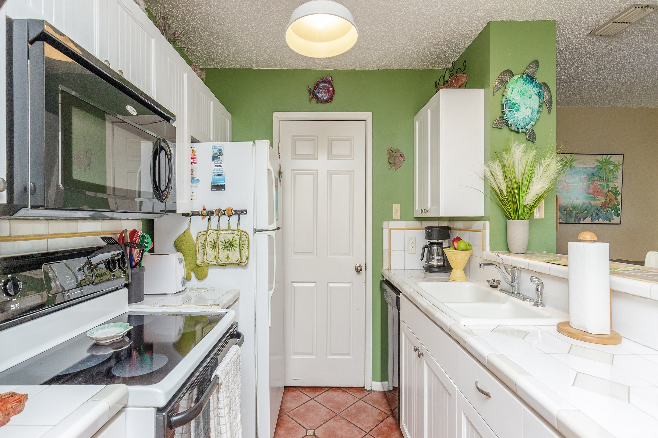 Fully equipped kitchen with coffee maker, toaster, cookware, dinnerware, and other kitchen essentials provided