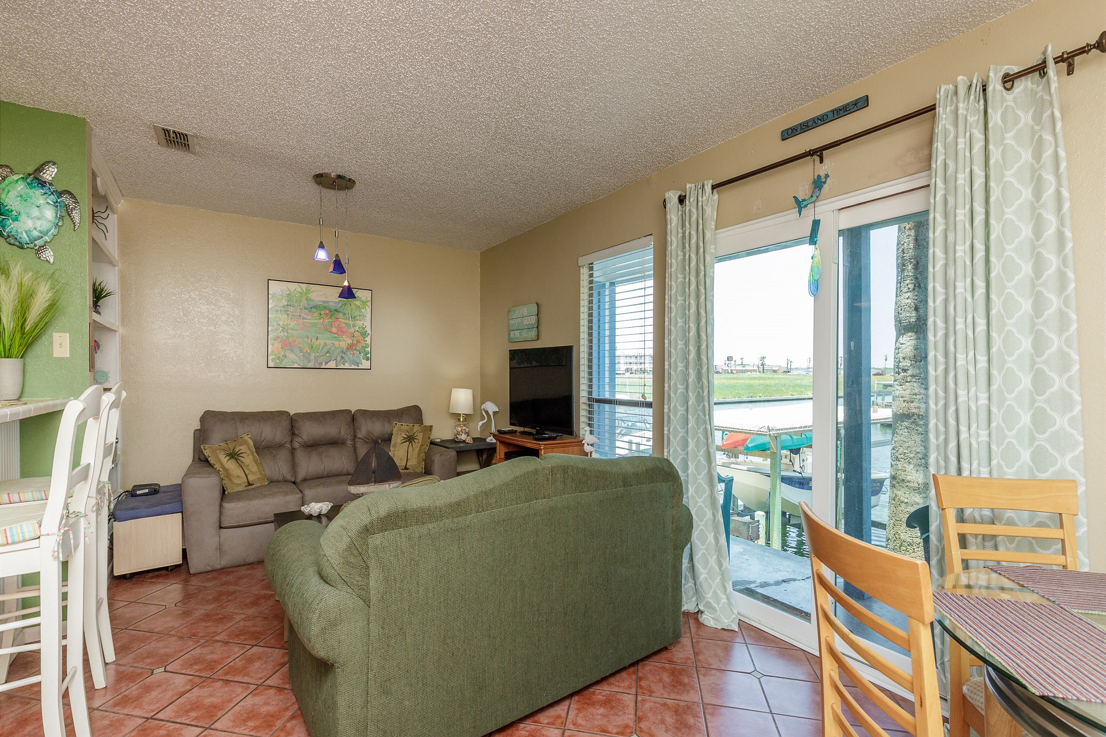 Living area with a view of the water from the couch and flat screen TV to enjoy 