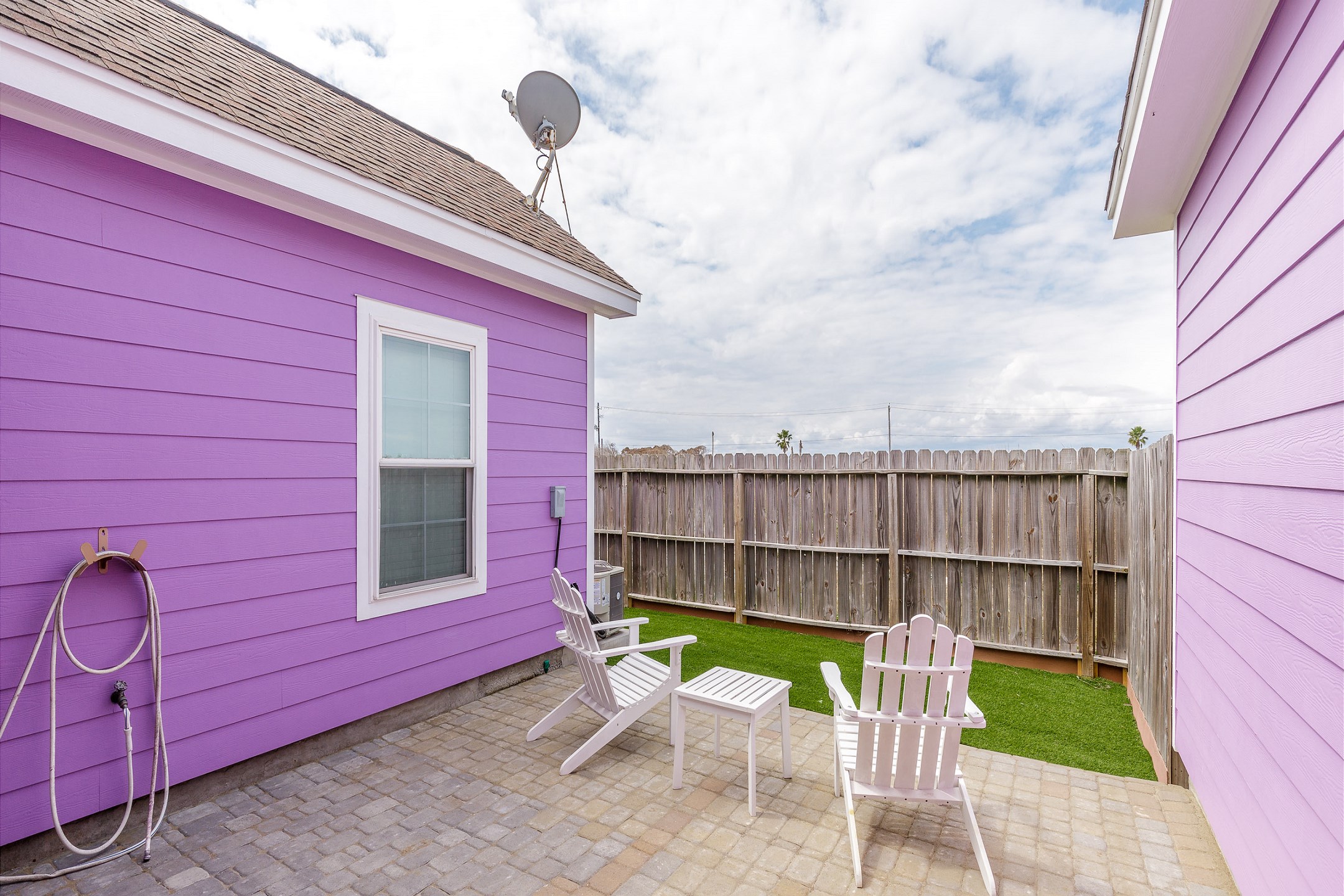 Private fenced in backyard with turf grass